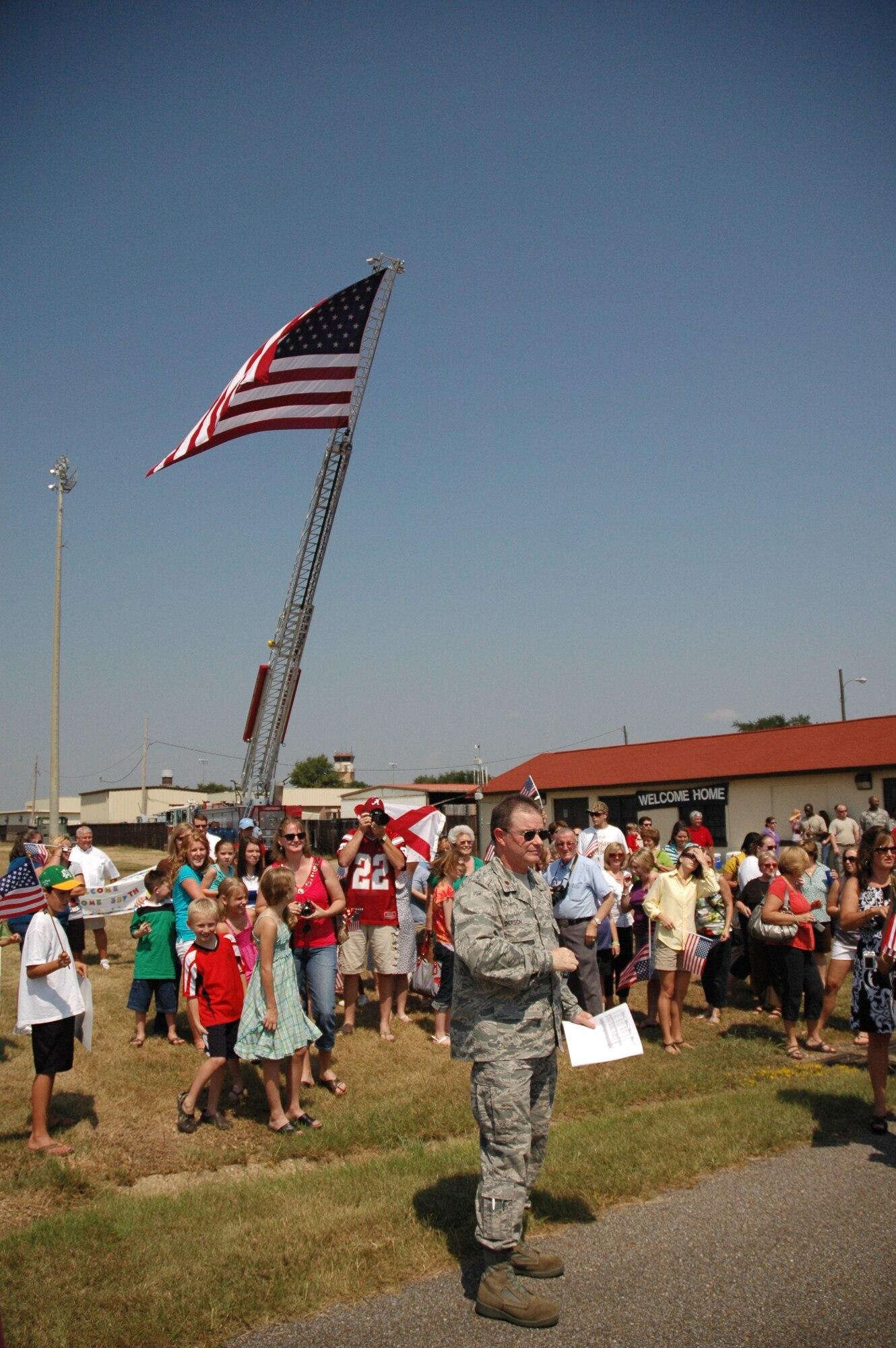 Wing Chaplain Maj. David Dersch and families await the landing of one of four C-130s at Maxwell AFB. Approximately 150 members of the 908th Airlift Wing recently returned from a four-month deployment to Southwest Asia. (Air Force photo by Lt. Col. Jerry Lobb) 
