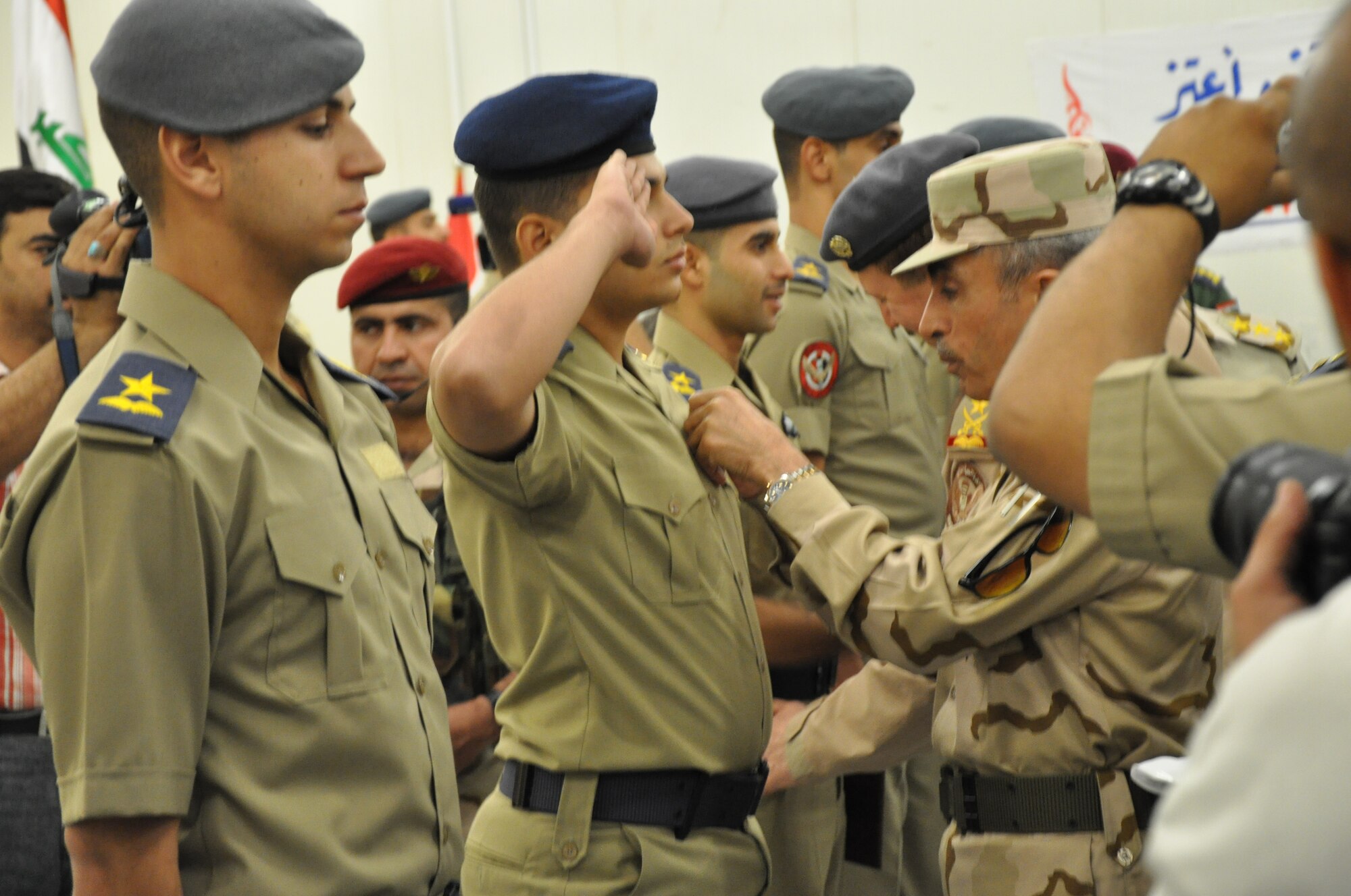 General Babaker, Chief of Staff, Iraqi Joint Forces, presents members of the Iraqi Air Force's newest pilots with their wings at an Iraqi Air Force College graduation ceremony, Sept. 21.  Eight of the graduates will fly fixed wing aircraft and 12 are slated for rotary wing aircraft. This graduating class brings the total number of Iraqi Air Force pilots trained in this program to 102.  (U.S. Air Force photo by Tech. Sgt. Mike Edwards)
