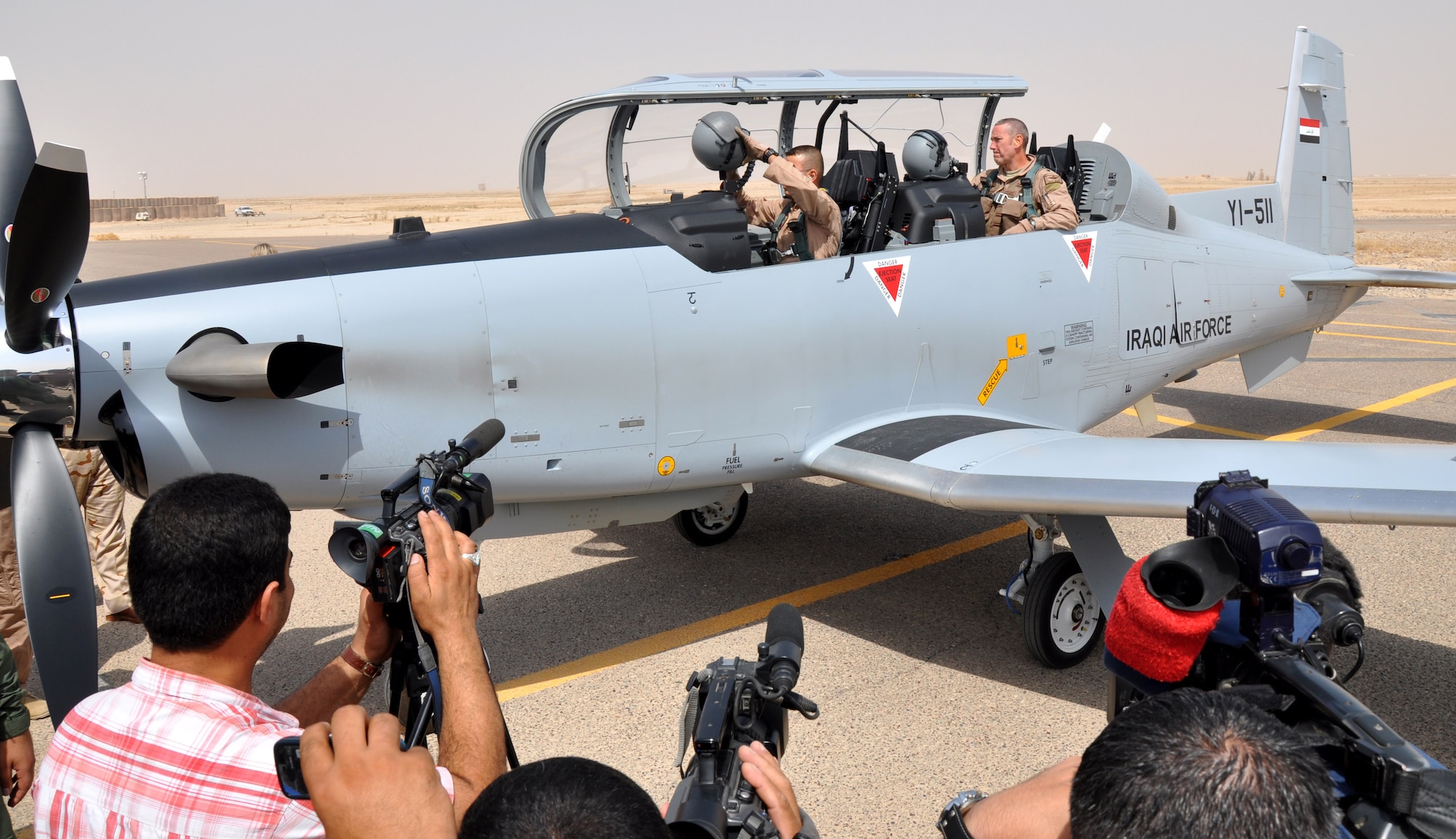 Members of the Iraqi media gather around a T-6A aircraft which arrived at Tikrit Air Base, Iraq, Sept.21.  This plane was part of a delivery of three new T-6A aircraft from Jordan, where they had been delivered by the manufacturer, Hawker-Beechcraft.  These planes were piloted to Iraq by members of the Iraqi Air Force, bringing their inventory to 11 aircraft in use for the pilot training program at the college.  (U.S. Air Force photo by Tech. Sgt. Mike Edwards)