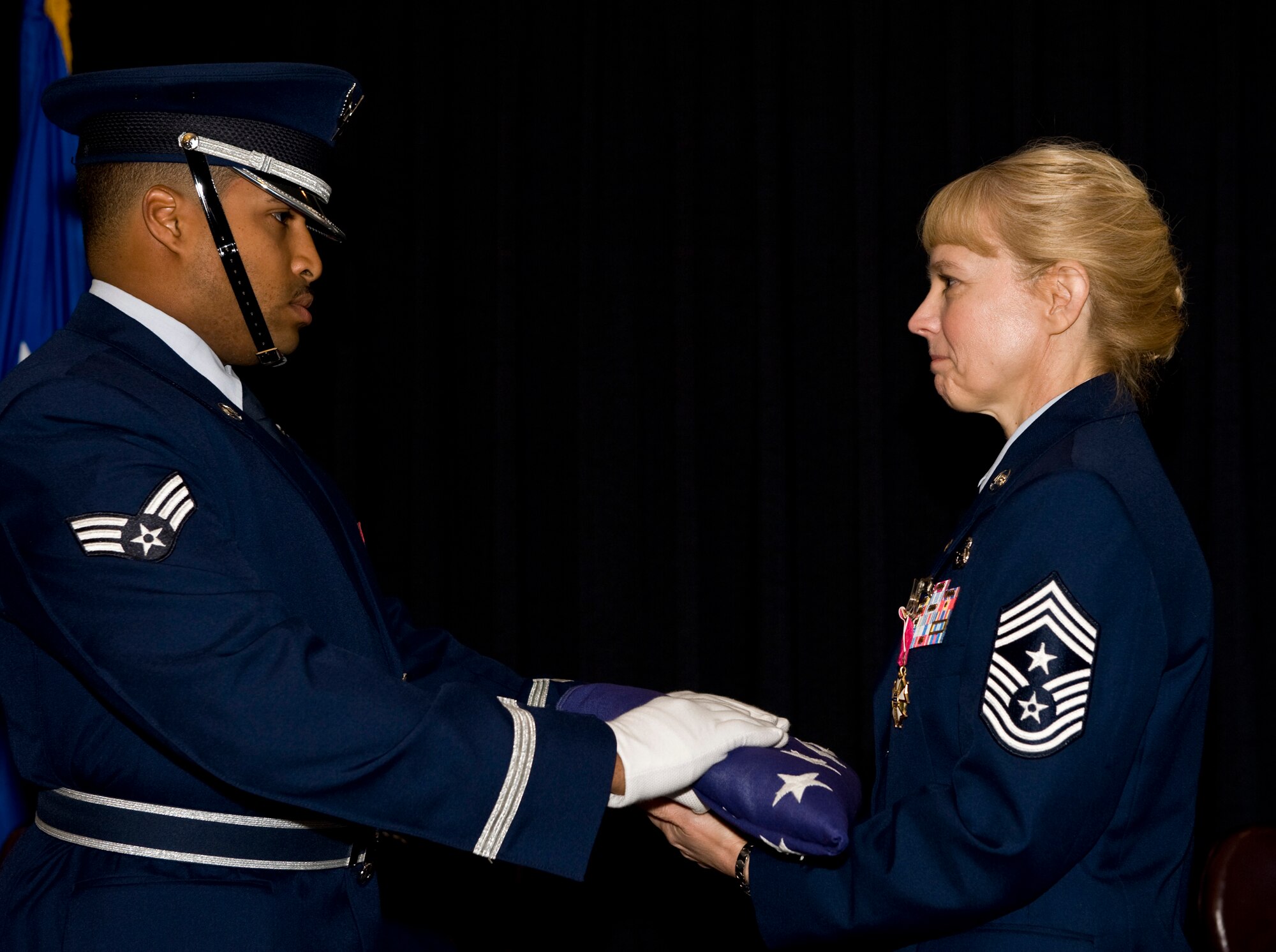 Senior Airman Gabriel Rosa, Ramstein Honor Guard and 1st Combat Communications Squadron, presents a U.S. flag to Chief Master Sgt.  Pamela A. Derrow, U.S. Air Forces in Europe command chief, during her retirement ceremony at Ramstein Air Base, Germany, Sept. 27, 2010. Chief Derrow retired after nearly 31 years in the Air Force. (U.S. Air Force photo/Tech. Sgt. Wayne Clark)