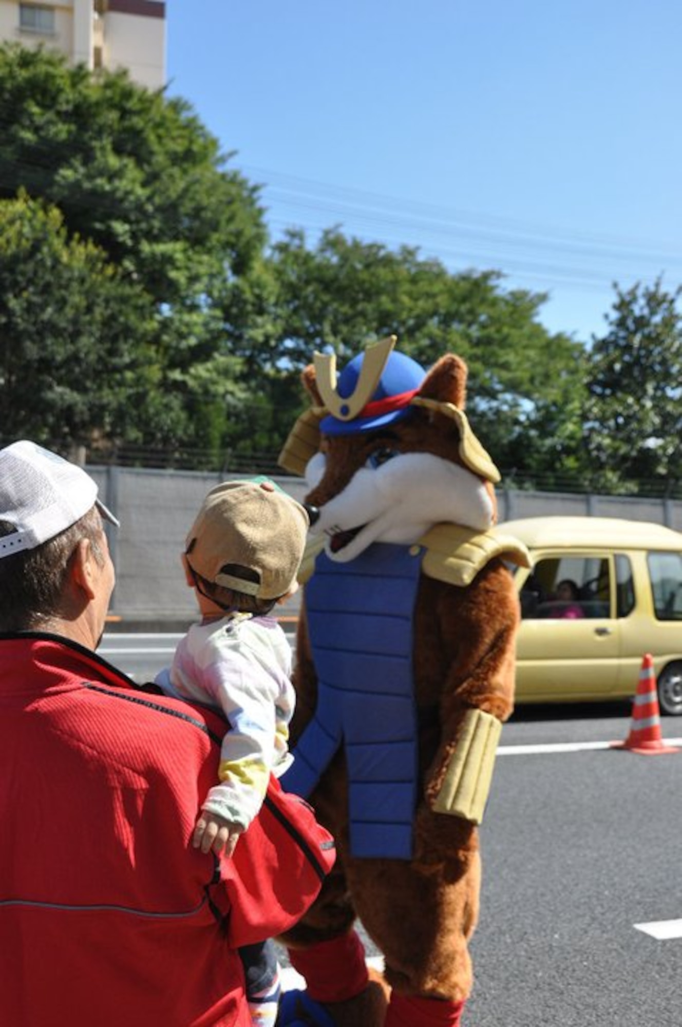 YOKOTA AIR BASE, Japan - The 374th Force Support Squadron's "Samurai Fox" greets a parade spectator at the 2010 Fussa International Fair parade, September 26.  The mascot was just one unique addition to this year's parade.  (U.S. Air Force photo/Capt. Tania Bryan)