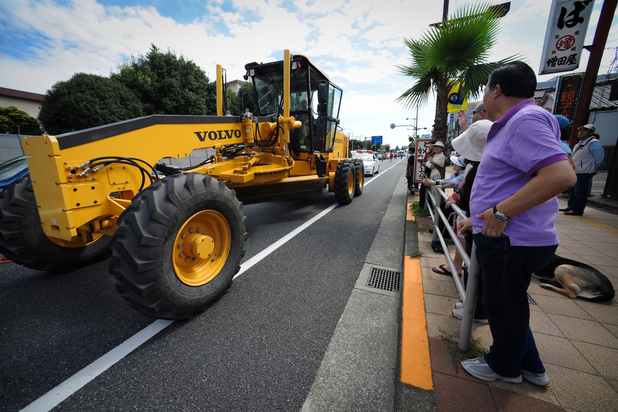 YOKOTA AIR BASE, Japan -- Senior Airman Steven Coakley, 374th Civil Engineer Squadron, drives a Grader down the street right outside Yokota's gates during the 2010 Fussa International Festival Parade, 26 Sept. The Grader was just one of the eleven vehicles used in everyday operations on Yokota Air Base that participated in the parade. (U.S. Air Force photo by Staff Sgt Stacy Moless)