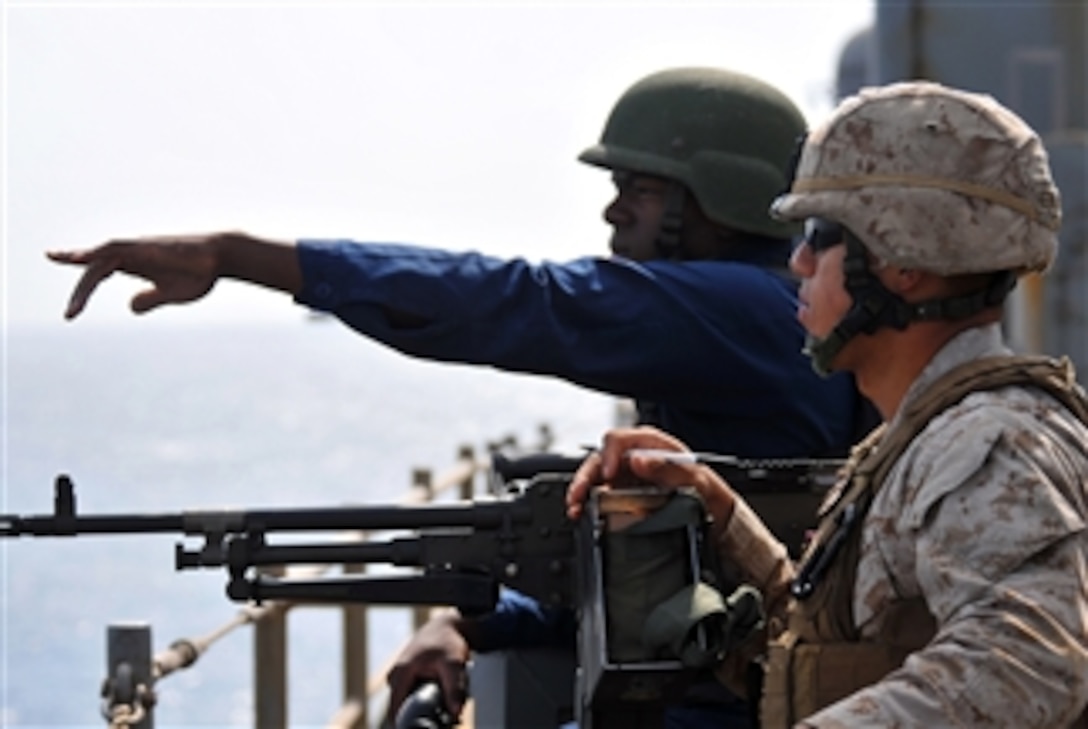 U.S. Navy Yeoman Seaman Corey Gathings points to a suspected pirated vessel in the Gulf of Aden while standing as starboard watch aboard the amphibious dock landing ship USS Pearl Harbor (LSD 52) on Sept. 23, 2010.  The Pearl Harbor is assigned to Combined Task Force 151, which is a multinational task force established to conduct counter-piracy operations in the Gulf of Aden and off the coast of Somalia.  