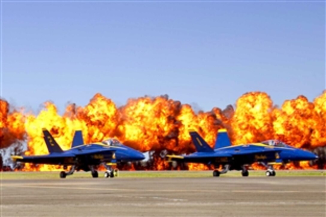 A fiery wall frames the Blue Angels, the U.S. Navy's demonstration squadron, during a Marine Air Ground Task Force event at the Kaneohe Bay Airshow on Marine Corps Air Station Kaneohe Bay, Hawaii, Sept. 25, 2010. During the performance, Marines assigned to the 3rd and 4th Force Reconnaissance companies carried out a simulated tactical recovery of aircraft personnel mission.