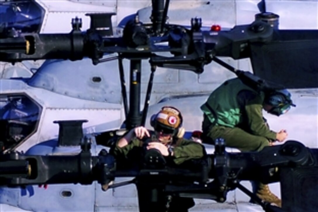 U.S. Marine Corps Lance Cpl. Christopher Horvet, center, conducts maintenance on the rotor of an AH-1Z Super Cobra helicopter aboard the amphibious assault ship USS Essex while under way in the Philippine Sea, Sept. 25, 2010. Horvet is assigned to Marine Attack Squadron 542.