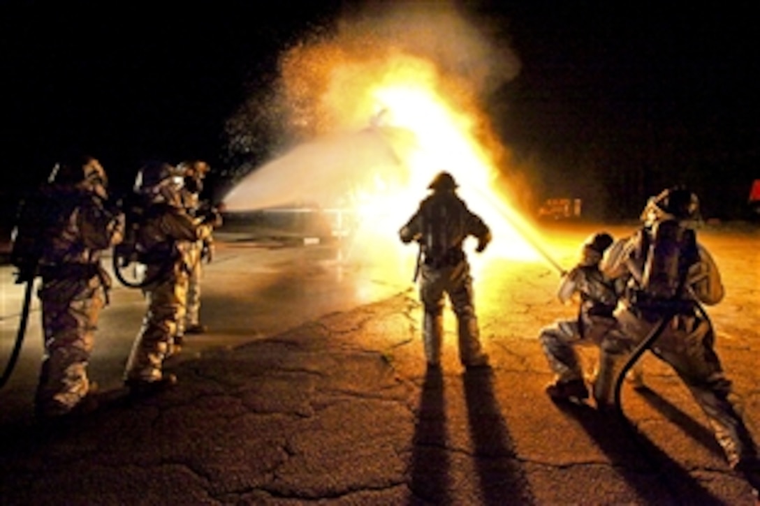 U.S. Marines assigned to aircraft rescue and firefighting units work together to put out a fire at the air station burn pit during a training fire exercise on Marine Corps Air Station, Beaufort, S.C., Sept. 21, 2010. Their gear protects them from flames that reach 1200 degrees.