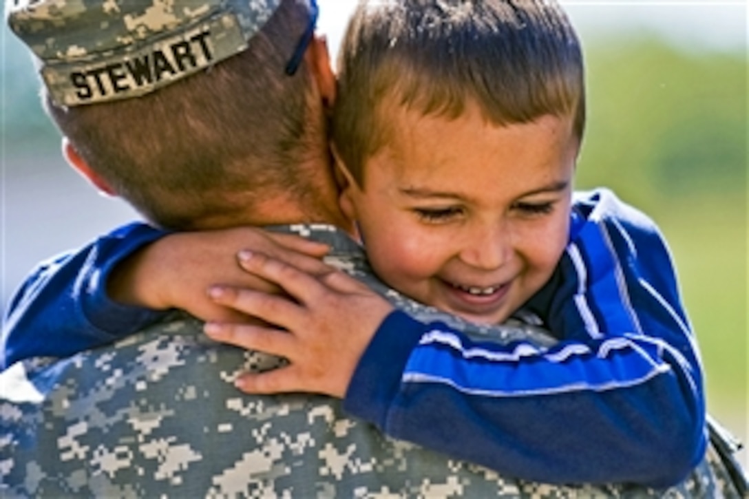 U.S. Army Staff Sgt. Patrick Stewart holds his fiance’s son at the departure ceremony for the 3-19th Agribusiness Development Team on Camp Atterbury Joint Maneuver Training Center, Ind., Sept. 25, 2010. The Indiana National Guard unit will deploy to Afghanistan to help Afghan leaders improve agricultural practices.