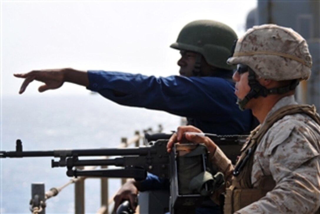 U.S. Navy Yeoman Seaman Corey Gathings points to a suspected pirated vessel in the Gulf of Aden while standing as starboard watch aboard the amphibious dock landing ship USS Pearl Harbor (LSD 52) on Sept. 23, 2010.  The Pearl Harbor is assigned to Combined Task Force 151, which is a multinational task force established to conduct counter-piracy operations in the Gulf of Aden and off the coast of Somalia.  