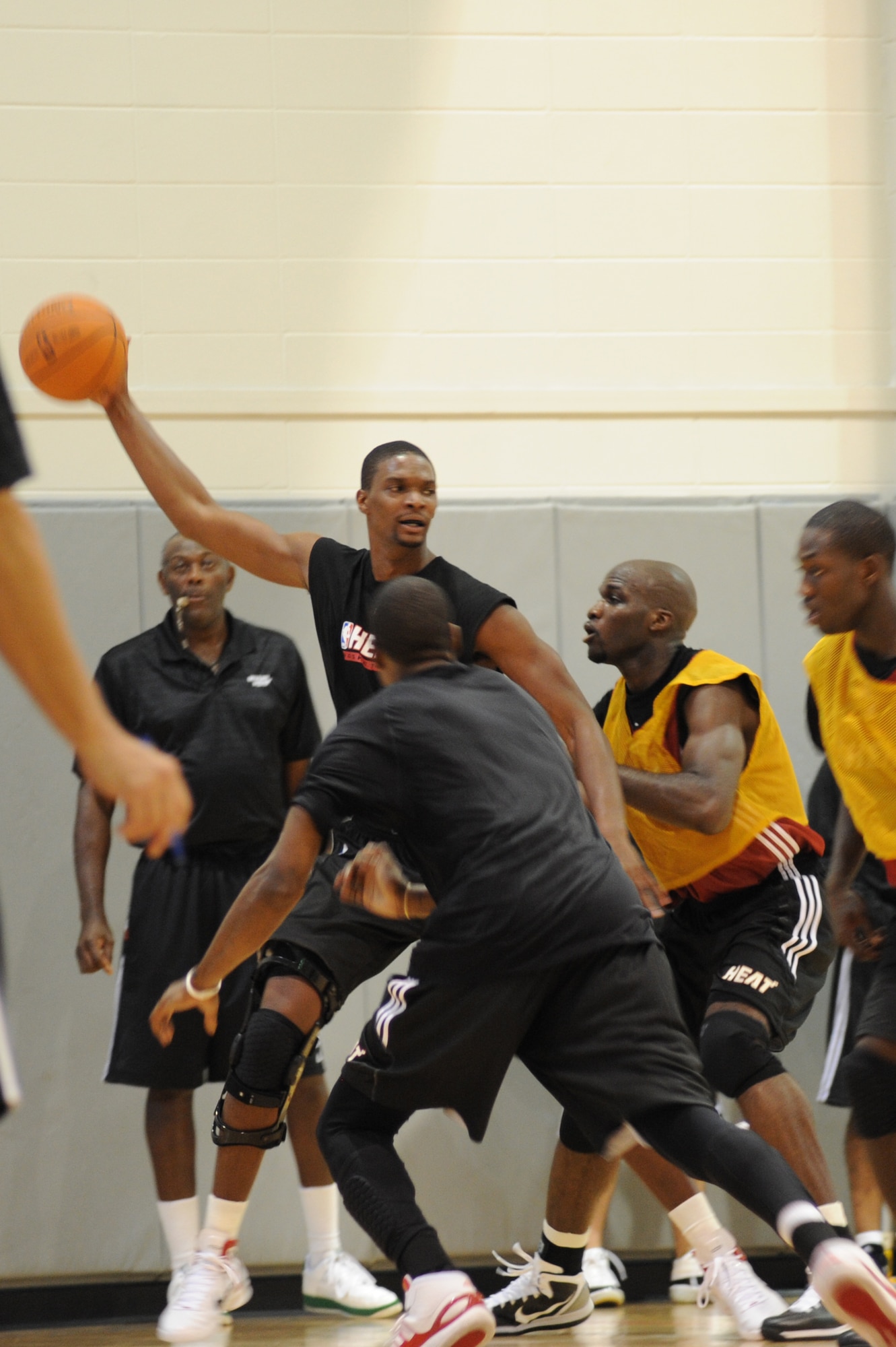 Chris Bosh, Miami HEAT forward, holds a basketball while looking for assistance his teammate's defense during a preseason practice session at the Aderholt Fitness Center at Hurlburt Field, Fla., Sept. 28, 2010. The team requested the use of the fitness center for their week-long training camp, and 1st Special Operations Wing leadership agreed to support the visit. (DoD photo by U.S. Air Force Senior Airman Sheila deVera) (RELEASED)