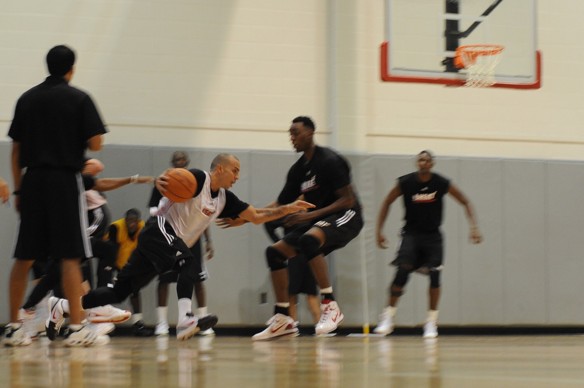 Carlos Arroyo, Miami HEAT guard, drives the basketball in front of Mickell Gladness, HEAT center, during a preseason practice session at the Aderholt Fitness Center at Hurlburt Field, Fla., Sept. 28, 2010. The team requested the use of the fitness center for their week-long training camp, and 1st Special Operations Wing leadership agreed to support the visit. (DoD photo by U.S. Air Force Senior Airman Sheila deVera) (RELEASED)
