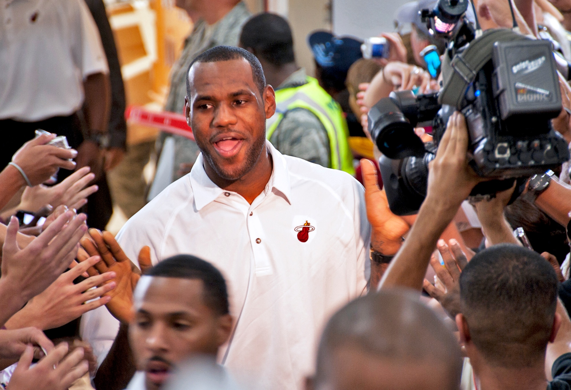 LeBron James walks into the spotlight of cameras and fans during a welcome reception at an Eglin Air Force Base hangar Sept. 28. The team chose Hurlburt Field's gym as the location for their week-long training camp. In between practice times they will interact with the military communities at both bases. (U.S. Air Force Photo/Samuel King, Jr.) 
