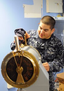 Electrician's Mate 3rd Class John Asija from Monroe, Conn., polishes an antique Engine Order Telegraph, or EOT, Sept. 27, 2010, that will be presented to the 628th Air Base Wing upon completion of standing up Joint Base Charleston. The EOT was used in earlier vessels from the 1800s to the mid-1900s. This device was used to power a vessel at a certain desired speed. The EOT used electronic light and sound signals, so when an order was made, the dial would be put in position and then ring in the engine room for acknowledgment. Electrician's Mate Asija is attached to Department of Transient Personnel, Naval Support Activity Charleston. (U.S. Navy photo/Mass Communication Specialist 1st Class Jennifer R. Hudson/released)