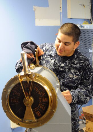 Electrician's Mate 3rd Class John Asija from Monroe, Conn., polishes an antique Engine Order Telegraph, or EOT, Sept. 27, 2010, that will be presented to the 628th Air Base Wing upon completion of standing up Joint Base Charleston. The EOT was used in earlier vessels from the 1800s to the mid-1900s. This device was used to power a vessel at a certain desired speed. The EOT used electronic light and sound signals, so when an order was made, the dial would be put in position and then ring in the engine room for acknowledgment. Electrician's Mate Asija is attached to Department of Transient Personnel, Naval Support Activity Charleston. (U.S. Navy photo/Mass Communication Specialist 1st Class Jennifer R. Hudson/released)