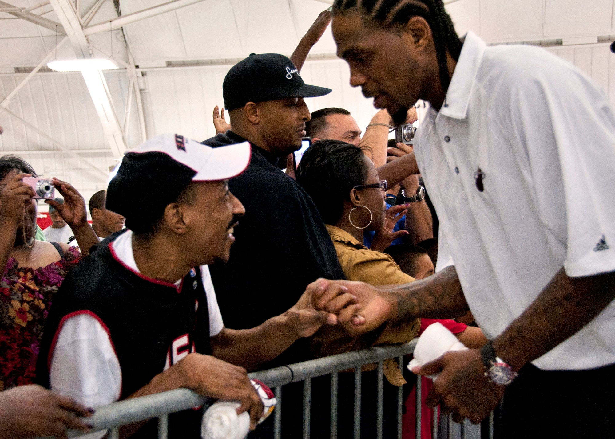 Udonis Haslem, Miami HEAT forward, shakes hands with a fan during a welcome reception at an Eglin Air Force Base hangar Sept. 27. The team chose Hurlburt Field's gym as the location for their week-long training camp. In between practice times they will interact with the military communities at both bases. (U.S. Air Force Photo/Samuel King, Jr.)