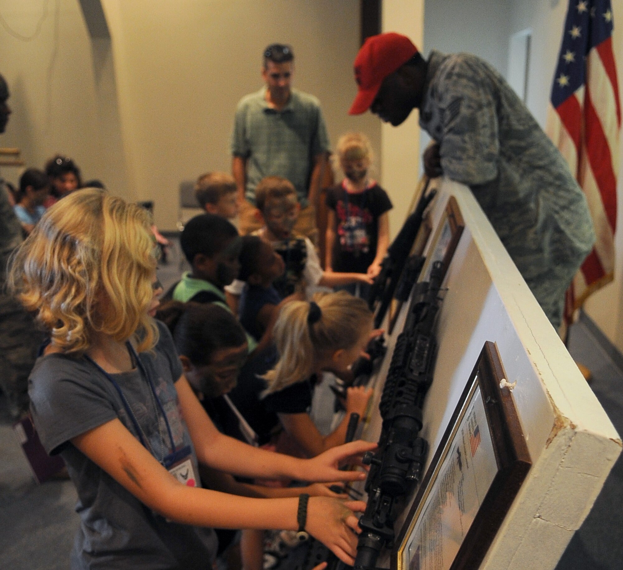 BARKSDALE AIR FORCE BASE, La. - Children view a display of weapons generally used by military members down-range during ?Operation Hero?, Sept. 25. More than 130 children and 90 parents participated in the mock-deployment line to help children understand what their military parents experience before deploying downrange. Some activities included a weapons qualification with paintball guns, chemical readiness preparation and a physical fitness assessment. (U.S. Air Force photo/Senior Airman Amber Ashcraft) (RELEASED)