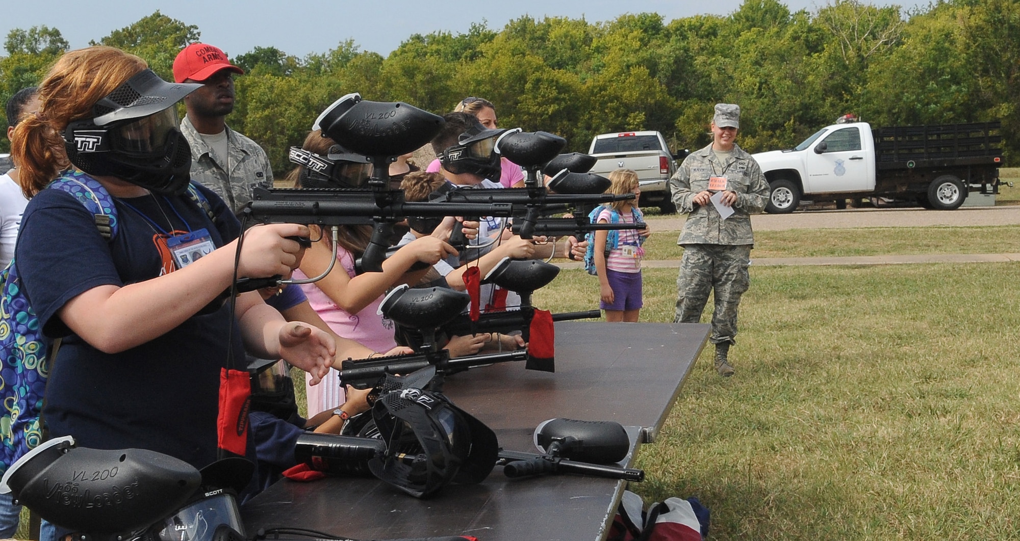 BARKSDALE AIR FORCE BASE, La. - Children fire paintball guns during a mock weapons qualifications test during Operation Hero, Sept. 25. More than 130 children and 90 parents participated in the mock-deployment line to help children understand what their military parents experience before deploying downrange. Some activities included a weapons qualification with paintball guns, chemical readiness preparation and a physical fitness assessment. (U.S. Air Force photo/Senior Airman Amber Ashcraft) (RELEASED)