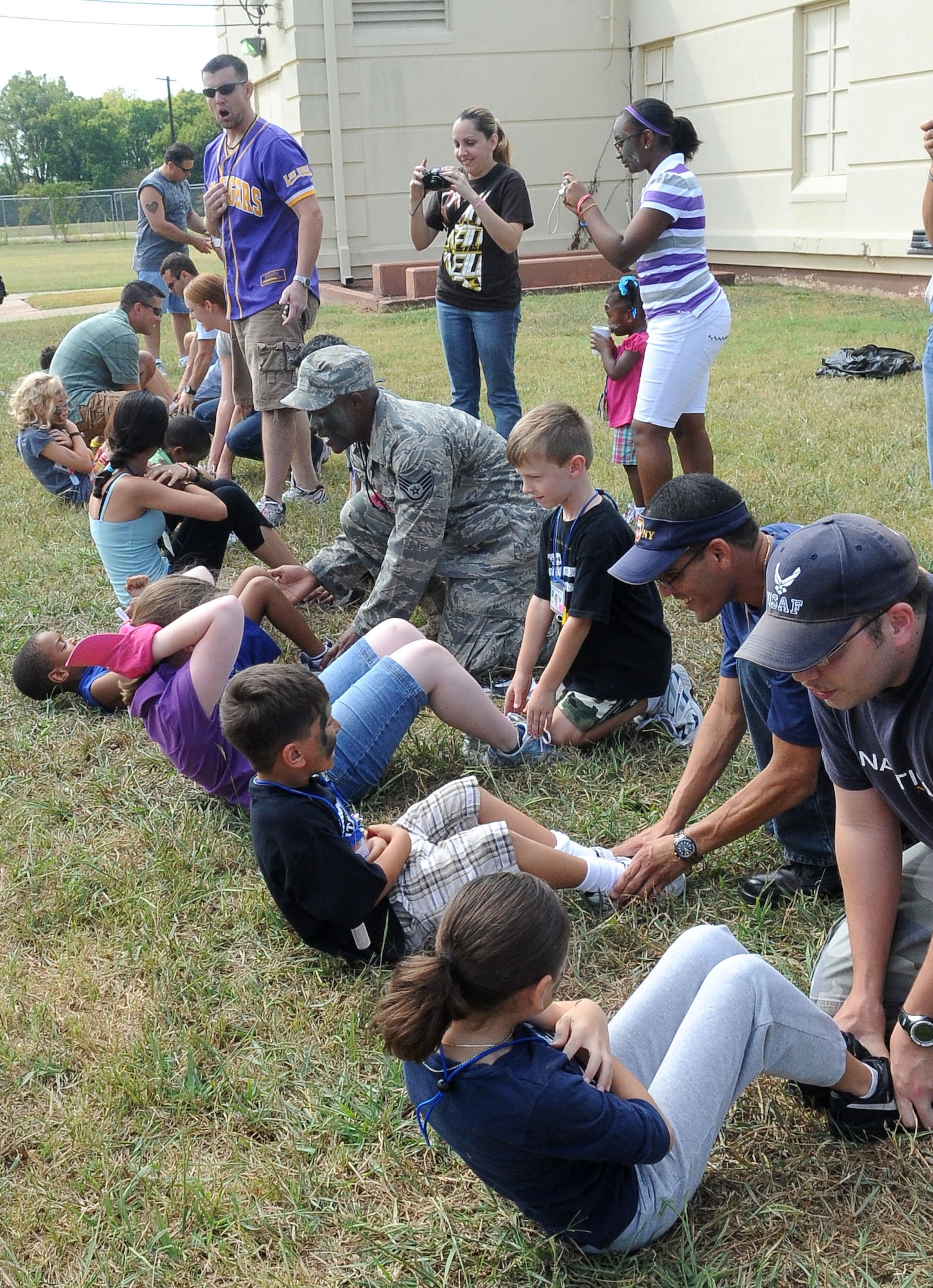 BARKSDALE AIR FORCE BASE, La. -- Children perform sit-ups for a mock fitness assessment test during Operation Hero, Sept. 25. More than 130 children and 90 parents participated in the mock-deployment line to help children understand what their military parents experience before deploying downrange. Some activities included a weapons qualification with paintball guns, chemical readiness preparation and a physical fitness assessment. (U.S. Air Force photo/Senior Airman Amber Ashcraft) (RELEASED)