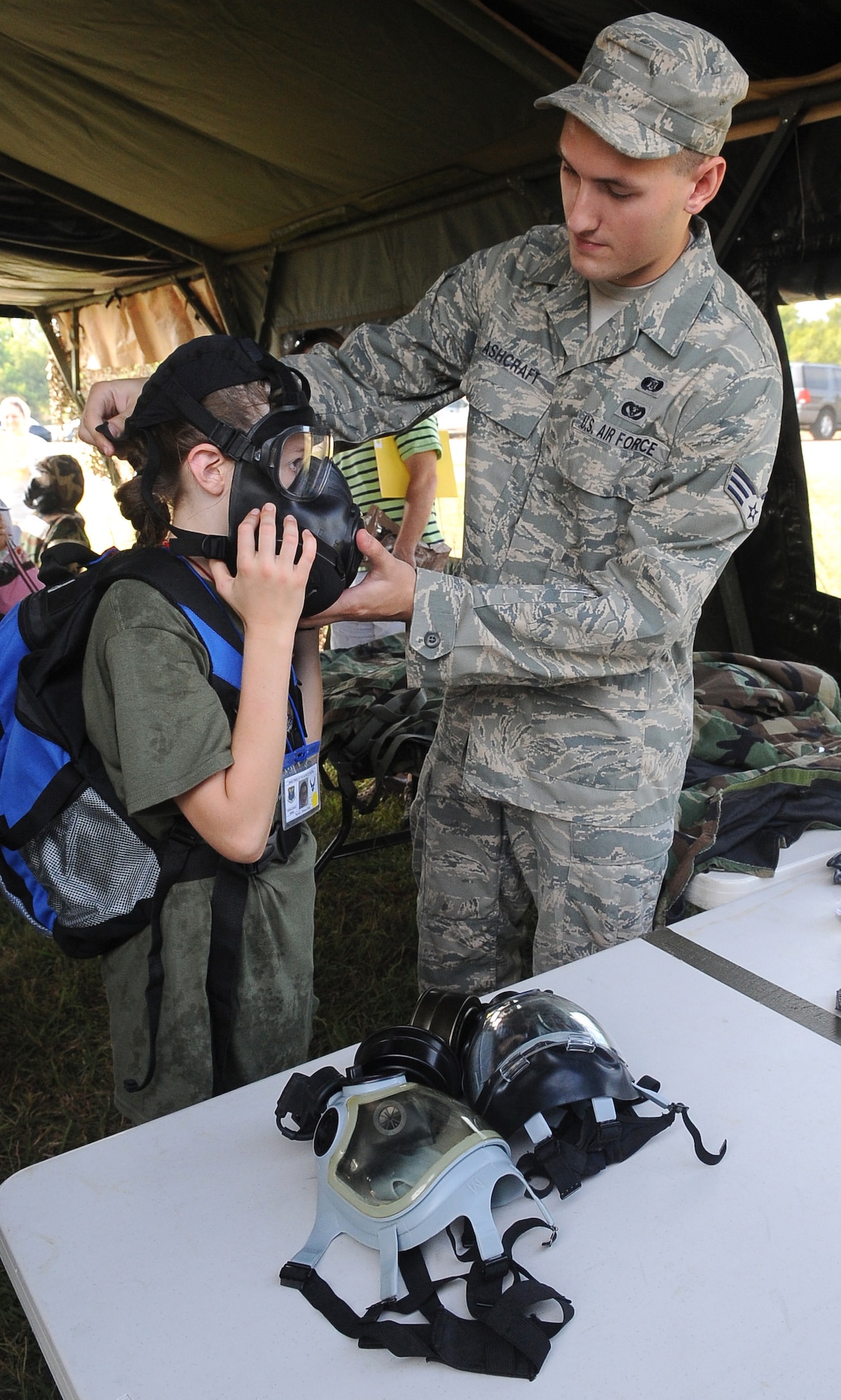 BARKSDALE AIR FORCE BASE, La. ? Senior Airman Brandon Ashcraft, 2nd Civil Engineer squadron, helps a child put on a gas mask during ?Operation Hero?, Sept. 25. More than 130 children and 90 parents participated in the mock-deployment line to help children understand what their military parents experience before deploying downrange. Some activities included a weapons qualification with paintball guns, chemical readiness preparation and a physical fitness assessment. (U.S. Air Force photo/Senior Airman Amber Ashcraft) (RELEASED)