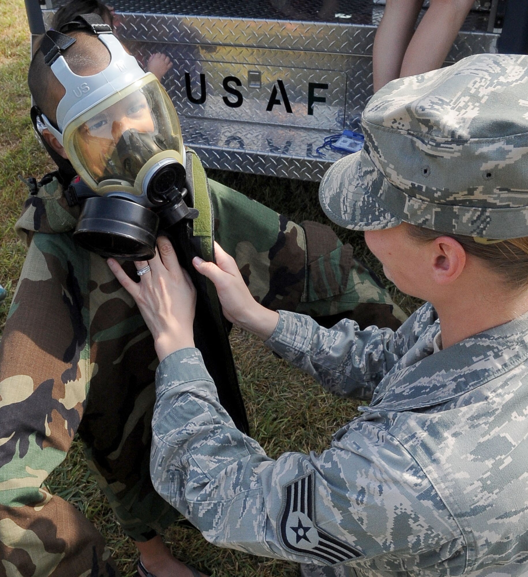 BARKSDALE AIR FORCE BASE, La. -- Staff Sgt. Elyce Holloway, 2nd Civil Engineer squadron, helps a child put on part of mission oriented protective posture gear during Operation Hero, Sept. 25. More than 130 children and 90 parents participated in the mock-deployment line to help children understand what their military parents experience before deploying downrange. Some activities included a weapons qualification with paintball guns, chemical readiness preparation and a physical fitness assessment. (U.S. Air Force photo/Senior Airman Amber Ashcraft) (RELEASED)