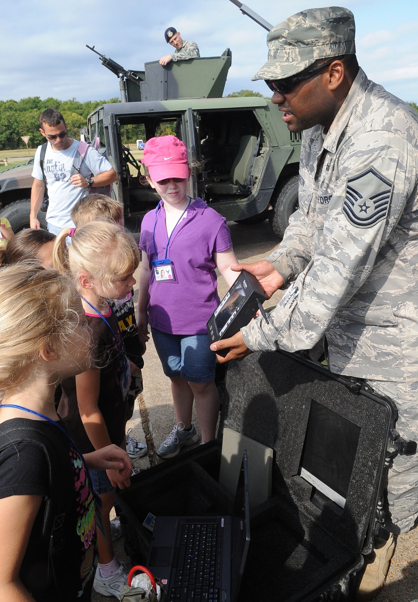 BARKSDALE AIR FORCE BASE, La. -- Master Sgt. James Martin, 2nd Civil Engineer Squadron, shows children equipment used by explosive ordinance disposal Airmen, during Operation Hero, Sept. 25. More than 130 children and 90 parents participated in the mock-deployment line to help children understand what their military parents experience before deploying downrange. Some activities included a weapons qualification with paintball guns, chemical readiness preparation and a physical fitness assessment. (U.S. Air Force photo/Senior Airman Amber Ashcraft) (RELEASED)