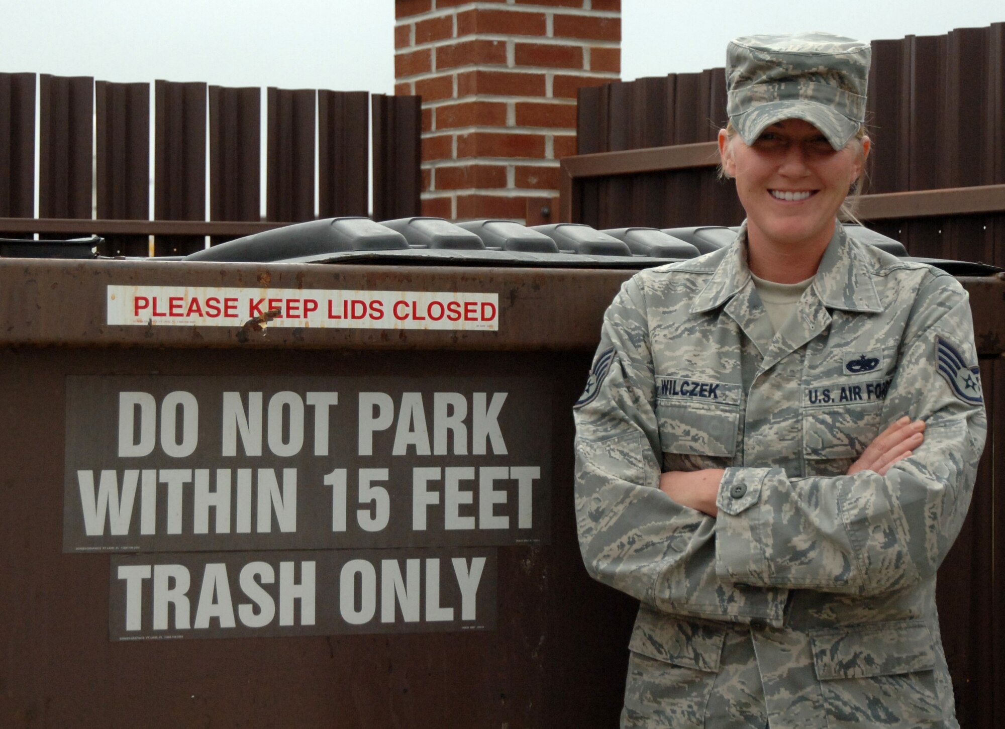 Staff Sgt. Emily Wilczek, 319th Aircraft Maintenance Squadron, poses for a picture in front of a dumpster Sept. 28 on Grand Forks Air Force Base, N.D. Sergeant Wilczek was selected for the Warrior of the Week for Sept. 27 to Oct. 1. (U.S. Air Force photo by Airman 1st Class Rachel Waller)
