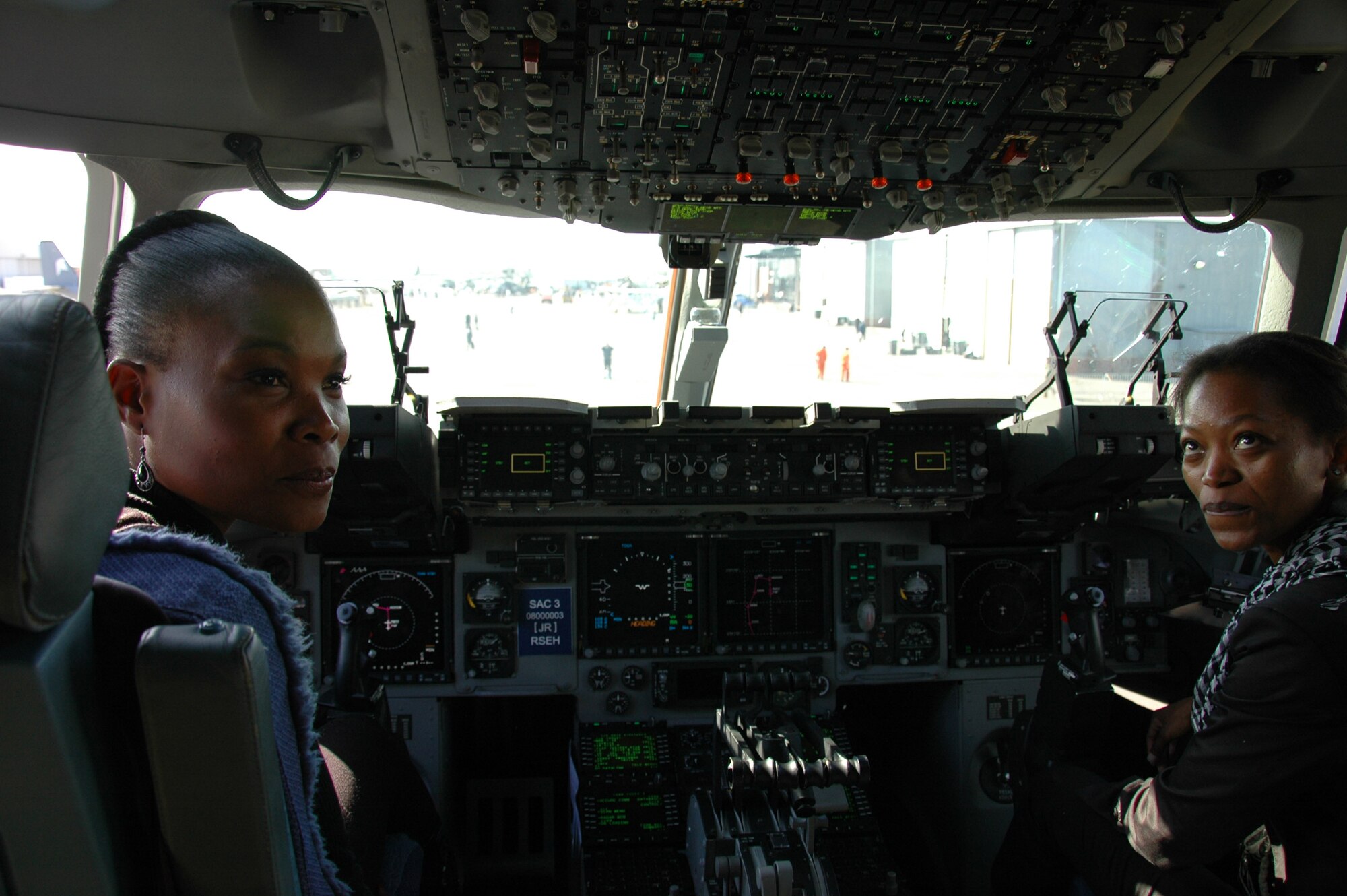 Two women experience what it's like to sit in the pilot's seat of a C-17 Globemaster III during the Africa Aerospace and Defense air and trade show held Sep 21-25 at Ysterplaat Air Force Base, Cape Town, South Africa. The five day event had representatives from 35 countries including a crew of four Charleston reservists who manned a C-17 static display and answered questions about the missions and capabilities of the aircraft. (U.S. Air Force photo/2nd Lt. Joe Simms)