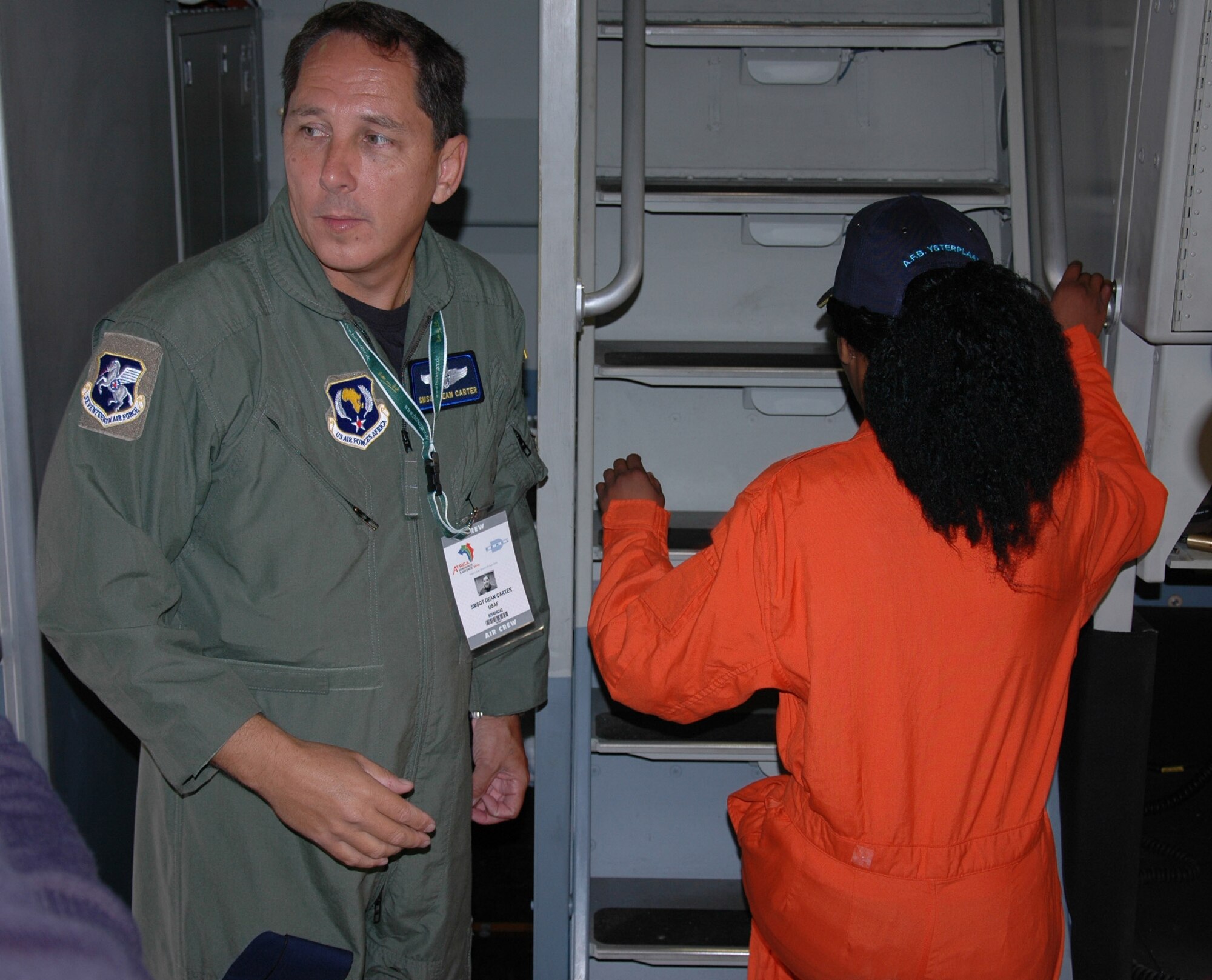 Senior Master Sgt. Dean Carter, 315th Airlift Wing, Charleston Air Force Base S.C., escorts a South African student to the flight deck of a C-17 Globemaster III during the Africa Aerospace and Defense airshow, Ysterplaat Air Force Base, Cape Town, South Africa. Sergeant Carter and reservists from Charleston AFB informed local and international attendees while maintaining a C-17 static display Sept. 21-25. (U.S. Air Force photo/2nd Lt. Joe Simms)