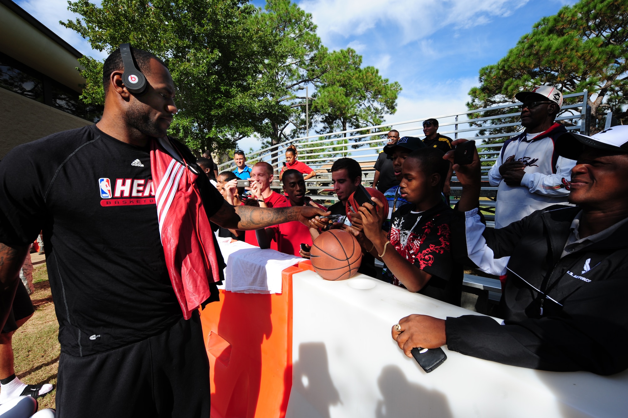 LeBron James, a Miami HEAT player, autographs a basketball for a fan before heading into the team’s first practice during the Miami HEAT 2010 Training Camp at the Aderholt Fitness Center, Hurlburt Field, Fla., Sept. 28, 2010. This is the first time in 23 years the HEAT has taken their training camp on the road.  Hurlburt Field will play host to the team’s contingent of 44 from Sep. 28, through Oct. 3, 2010.  Players and staff have allotted time throughout the week to visit with Air Commandos at different work centers across base. (DoD Photo by Staff Sgt. Stephanie Jacobs/RELEASED)