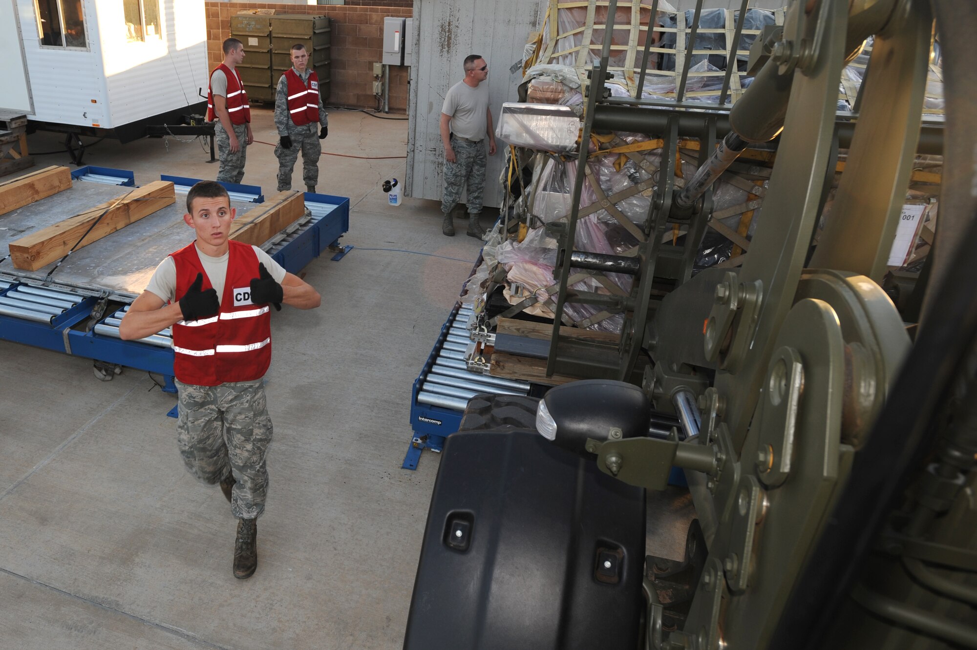 Airman 1st Class Joshua Allison, 27th Special Operations Logistics Readiness Squadron, instructs the lift driver to lower the cargo onto the pallet Sept 27. After the cargo is set down. it is weighed to make sure that they do not exceed an aircraft's carrying limits. (U.S. Air Force photo by Senior Airman Maynelinne De La Cruz)