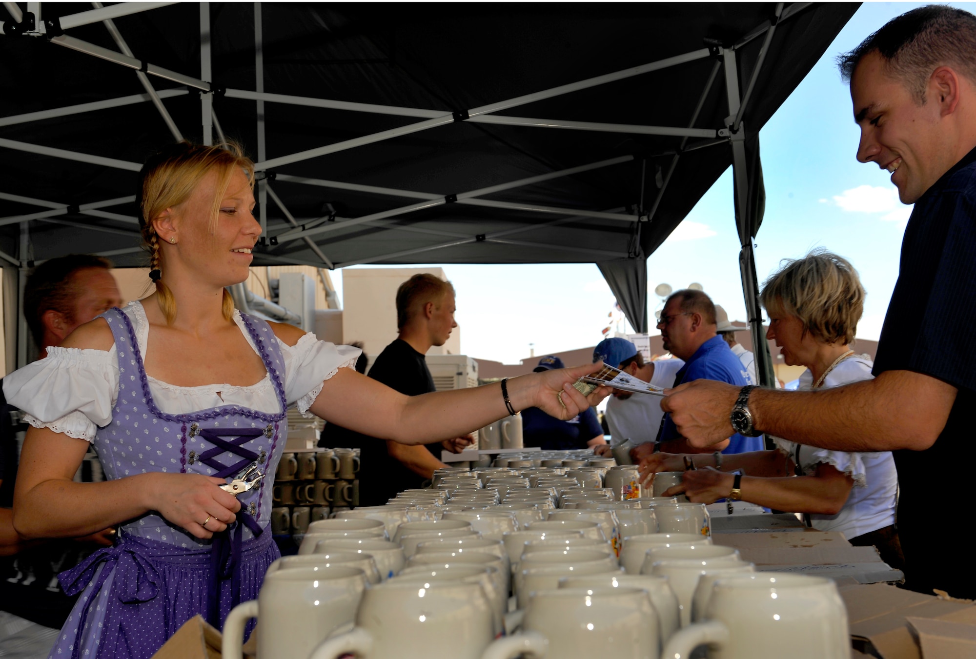 HOLLOMAN AIR FORCE BASE, N.M. -- 1st Lt. Kirsten Blank, German Flying Training Center, hands out beer steins to guests attending the 14th Annual Oktoberfest celebration Sept. 25, 2010. The German stein is decorated differently each year and can be collected as a souvenir by guests who attend Oktoberfest. (U.S. Air Force photo by Senior Airman Veronica Stamps / Released)