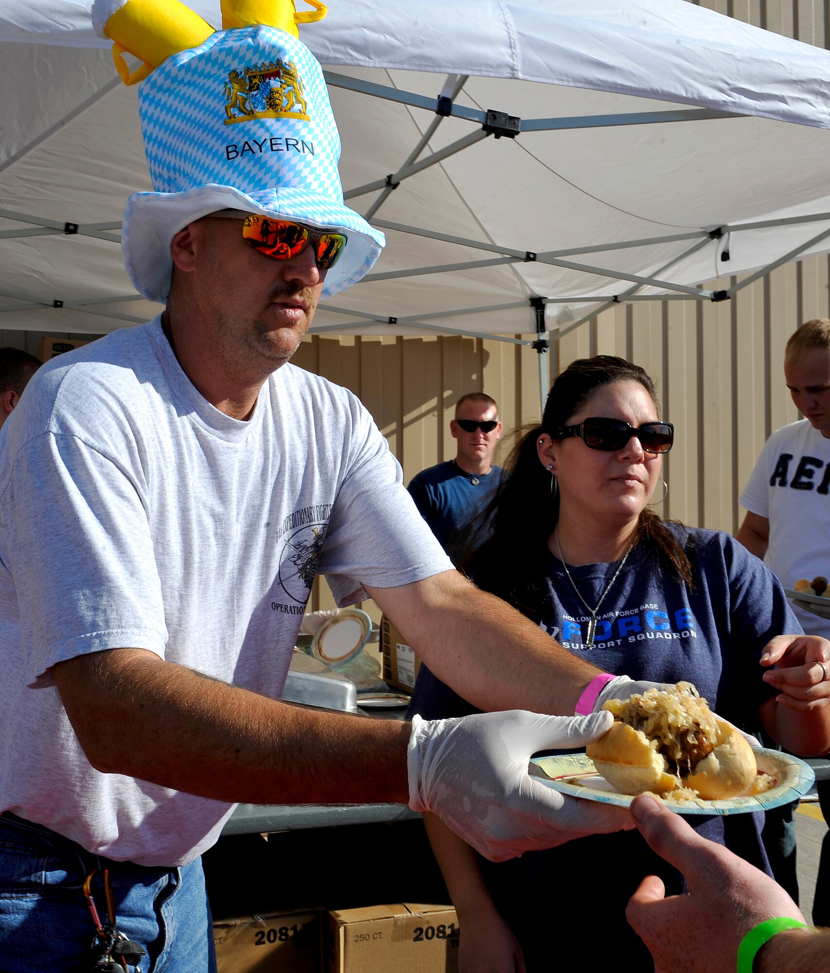 HOLLOMAN AIR FORCE BASE, N.M. -- Master Sgt. Mike Entinger, 49th Maintenance Operation Squadron, serves bratwurst with sauerkraut during the 14th Annual Oktoberfest celebration Sept. 25, 2010. Guests from on base and the local community also enjoyed the taste of pretzels, schnitzel and potato salad. (U.S. Air Force photo by Senior Airman Veronica Stamps / Released)