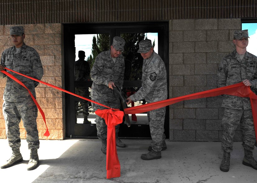 HOLLOMAN AIR FORCE BASE, N.M. -- Col. Donald Van Patten, 49th Maintenance Group commander, and Master Sgt. Greggory Sinclair, 8th Aircraft Maintenance Unit specialist flight chief, cut a ribbon to celebrate the opening of the 8th AMU building, Sept. 16, 2010. After five months of renovation, Colonel Van Patten welcomed over 300 Airmen from the 8th AMU into their remodeled building. The 8th AMU invested $2 million toward the renovation of their building where they can continue their support for F-22 operations. (U.S. Air Force photo by Senior Airman Veronica Stamps / Released)