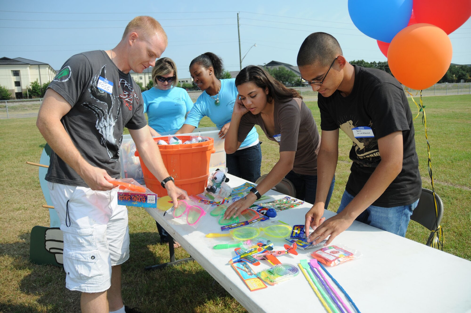 Airman 1st Class Scott Foss, left, 332nd Training Squadron, joins fellow students Airman 1st Class Jody Aquilar and Airman Basic John Incardona in arranging games and prizes for the Michel Middle School Health Fair Sept. 18. In the background, Airman 1st Class Melissa Burrows, left, and Senior Airman Ebony Mull, 81st Medical
Operations Squadron, join in the volunteer effort.  (U.S. Air Force photo by Kemberly Groue)