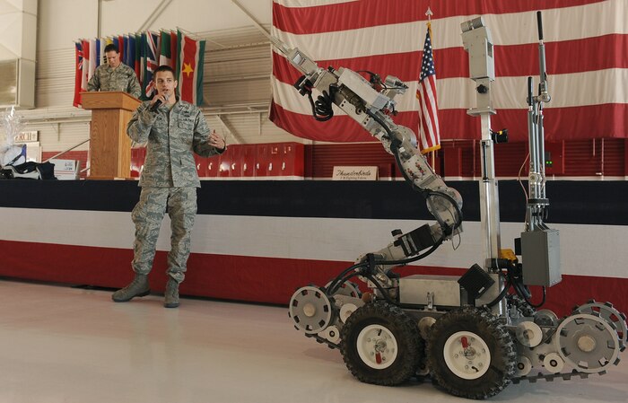 NELLIS AIR FORCE BASE, Nev.-- Airman 1st Class Tukker Willson, 99th Civil Engineering Squadron Explosive Ordnance Disposal apprentice, explains the use of an F-6 Robotic Platform during the Nellis, Creech and Nevada Test and Training Range Retiree Appreciation Day Sept. 25. The event included health screenings, K-9 and explosive ordnance disposal demonstrations, entertainment, door prizes and a free lunch for more than 800 attendees at the Thunderbird hangar. (U.S Air Force Photo / Senior Airman Stephanie Rubi)