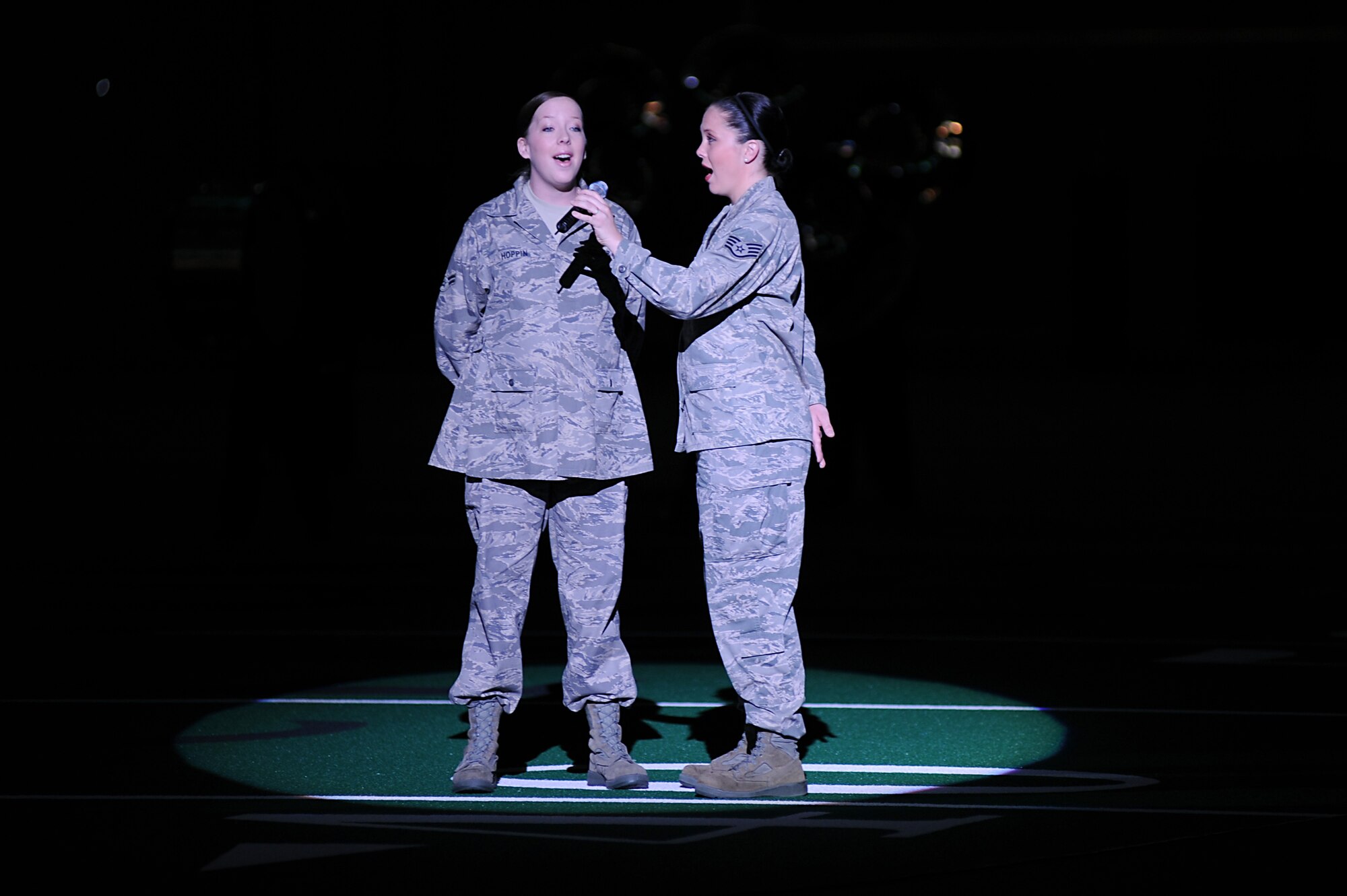 Airman 1st Class Betsy Hoppin (left), 319th Logistics Readiness Squadron, and Staff Sgt. Faith Walker, 319th Force Support Squadron, sing the National Anthem before the start of the University of North Dakota military appreciation football game Sept. 25 at the Alerus Center in Grand Forks, N.D. The Grand Forks Chamber of Commerce Military Affairs Committee supplied food and tickets to military members and their families. The UND Fighting Sioux defeated the Northwestern State University Demons 49-24. (U.S. Air Force photo by Senior Airman Amanda N. Stencil)