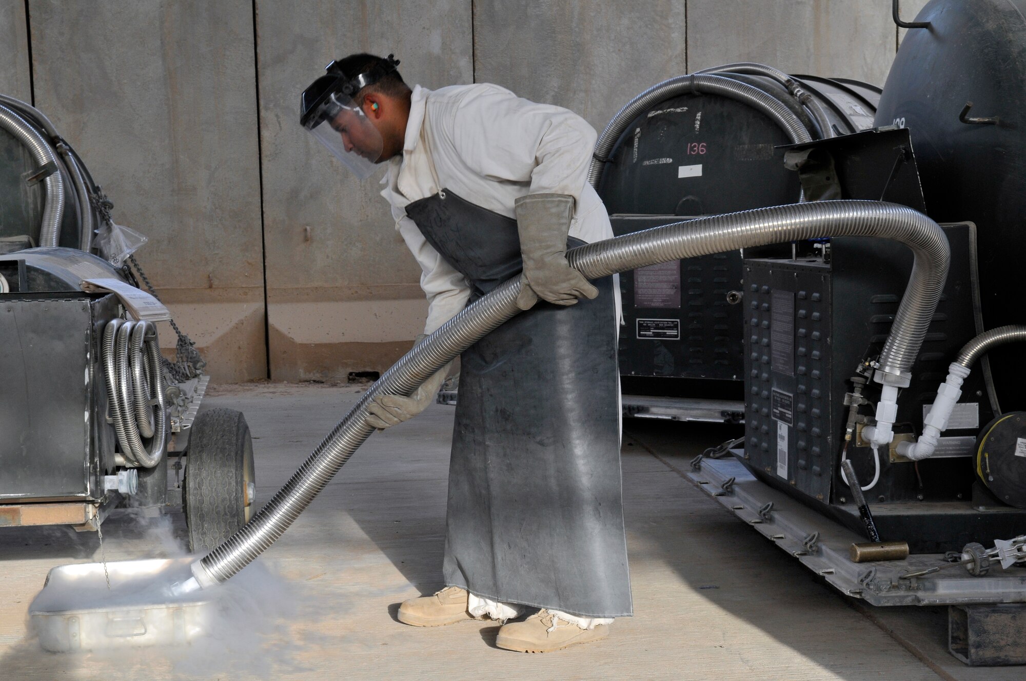 Staff Sgt. Rogelio Guerrero, 332nd Expeditionary Logistics Readiness Squadron Fuel distribution supervisor, drains a liquid oxygen servicing hose for storage after filling a LOX cart, which is used to fill LOX converters, on F-16 Fighting Falcons Sept. 24, 2010, Joint Base Balad, Iraq. Because of its cryogenic nature, liquid oxygen can cause the materials it touches to become extremely brittle. Sergeant Guerrero is a native of San Antonio, Texas, deployed from Dyess Air Force Base, Texas. (U.S. Air Force photo/Staff Sgt. Phillip Butterfield)