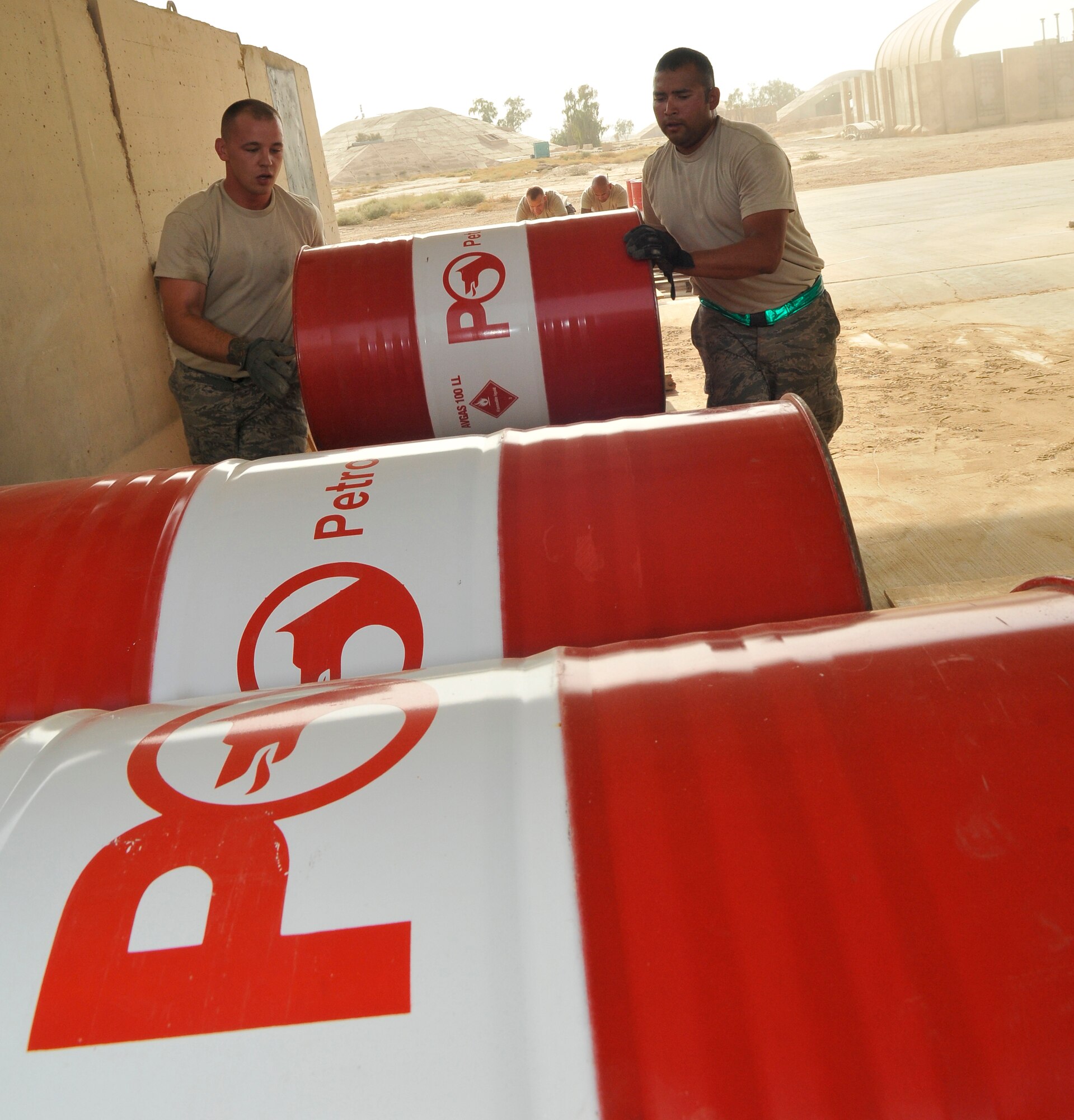 Staff Sergeants Robert Head and Rogelio Guerrero, 332nd Expeditionary Logistics Readiness Squadron fuels technicians, roll barrels of aviation gas up a ramp to stack them for storage Sept. 24, 2010, Joint Base Balad, Iraq. AvGas is a high-octane aviation fuel used to power aircraft and racing cars. The barrels are stored on their sides to ease the stress on the barrels when the gas expands in the heat. Sergeant Head is a native of Elkhart, Ind., deployed from Seymour Johnson Air Force Base, N.C., and Sergeant Guerrero is a native of San Antonio, Texas, deployed from Dyess Air Force Base, Texas. (U.S. Air Force photo/Staff Sgt. Phillip Butterfield) 