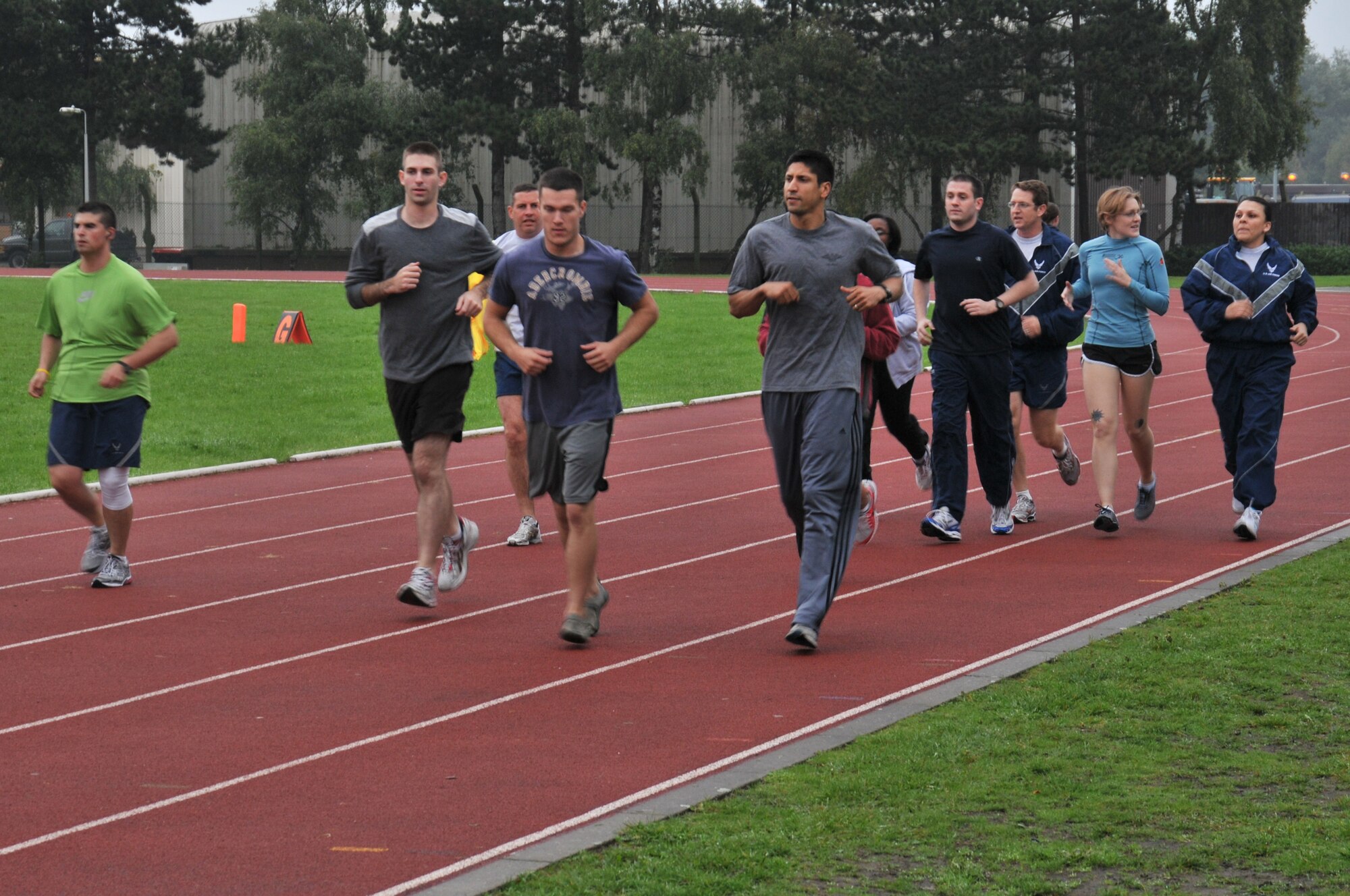 Staff Sgt. Eduardo DeSouza (center in gray t-shirt and long pants), leads a warm-up during the PT Run Class at the RAF Lakenheath running track Sept. 27. The class is held Monday through Thursday and is designed to help individuals with the 1.5-mile run portion of the Air Force PT test. (U.S. Air Force photo/Senior Airman David Dobrydney)