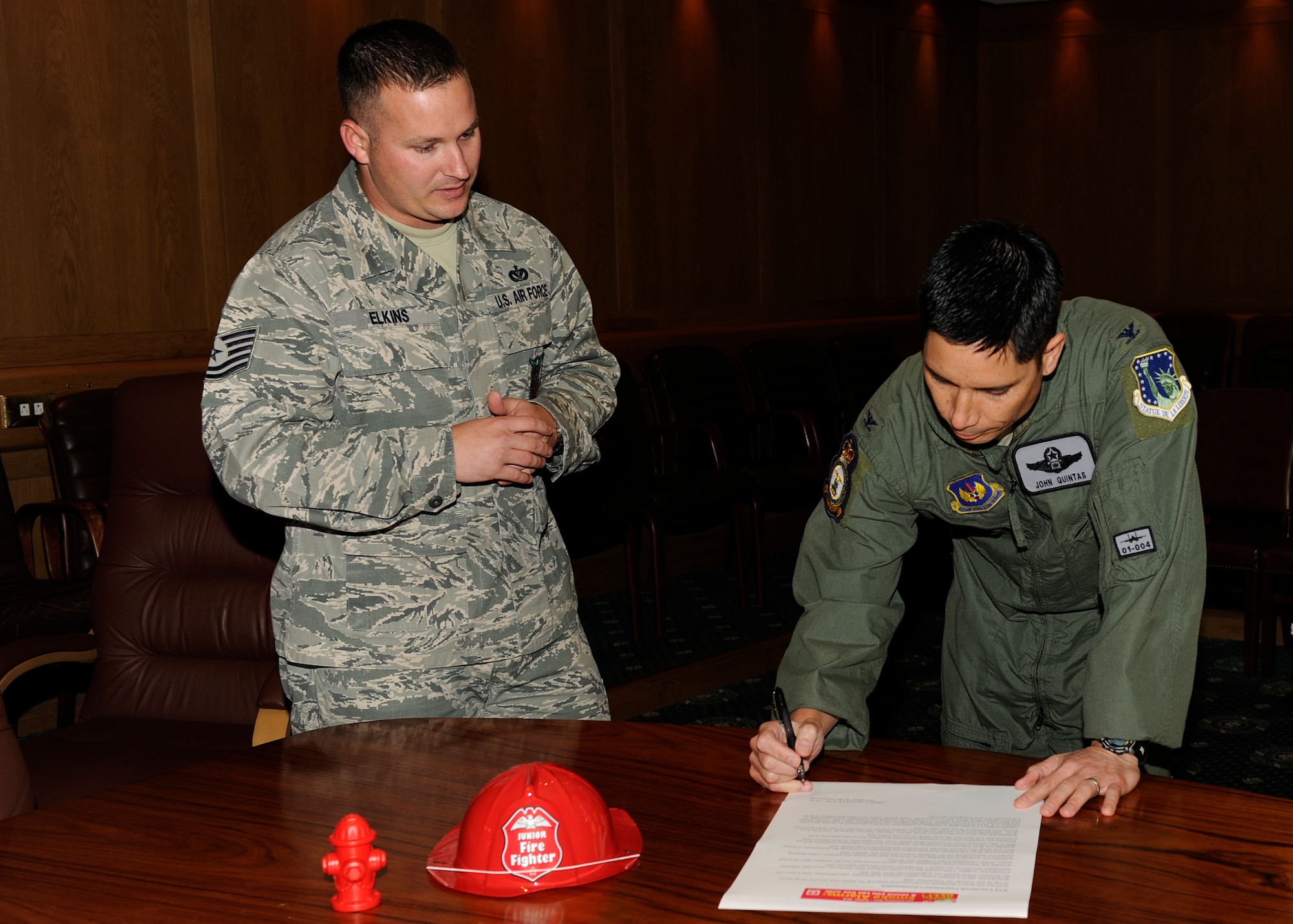 (left to right) Tech. Sgt. Nathan Elkins, 48th Civil Engineer Squadron fire inspector, watches as 48th Fighter Wing Commander Col. John Quintas signs the National Fire Prevention Week proclamation at Wing Headquarters on Sept. 27. National Fire Prevention Week consists of a series of events that are designed to help educate people, young and old, on how to be safe in the kitchen, who to call when a fire happens, what measures to take to prevent fires and other helpful information. (U.S. Air Force Photo/Airman 1st Class Tiffany M. Deuel)