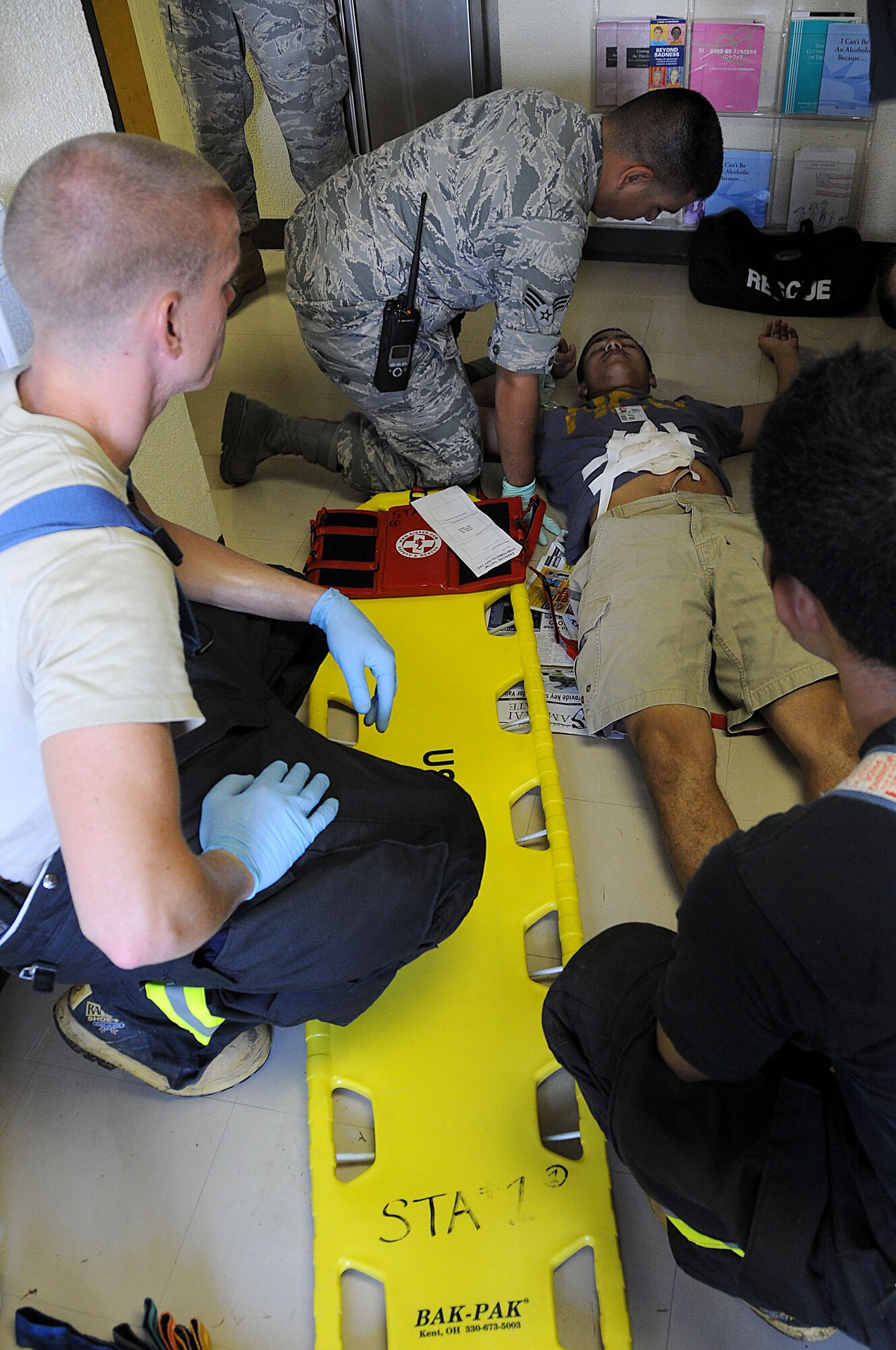 Kadena Air Base medical personnel prepare to place an injured bystander on a litter to be placed in an ambulance during an exercise, Sept. 28. This exercise tested the 18th Wing's ability to respond to a simulated "shots fired" scenario.  (U.S. Air Force photo/Staff Sgt. Darnell T. Cannady)