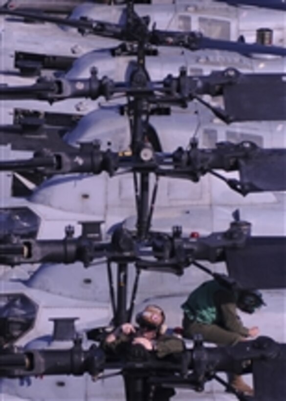 U.S. Marine Corps Lance Cpl. Christopher Horvet (left) assigned to Marine Attack Squadron 542, conducts maintenance on the rotor of an AH-1Z Super Cobra helicopter aboard the forward-deployed amphibious assault ship USS Essex (LHD 2) while underway in the Philippine Sea on Sept. 25, 2010.  