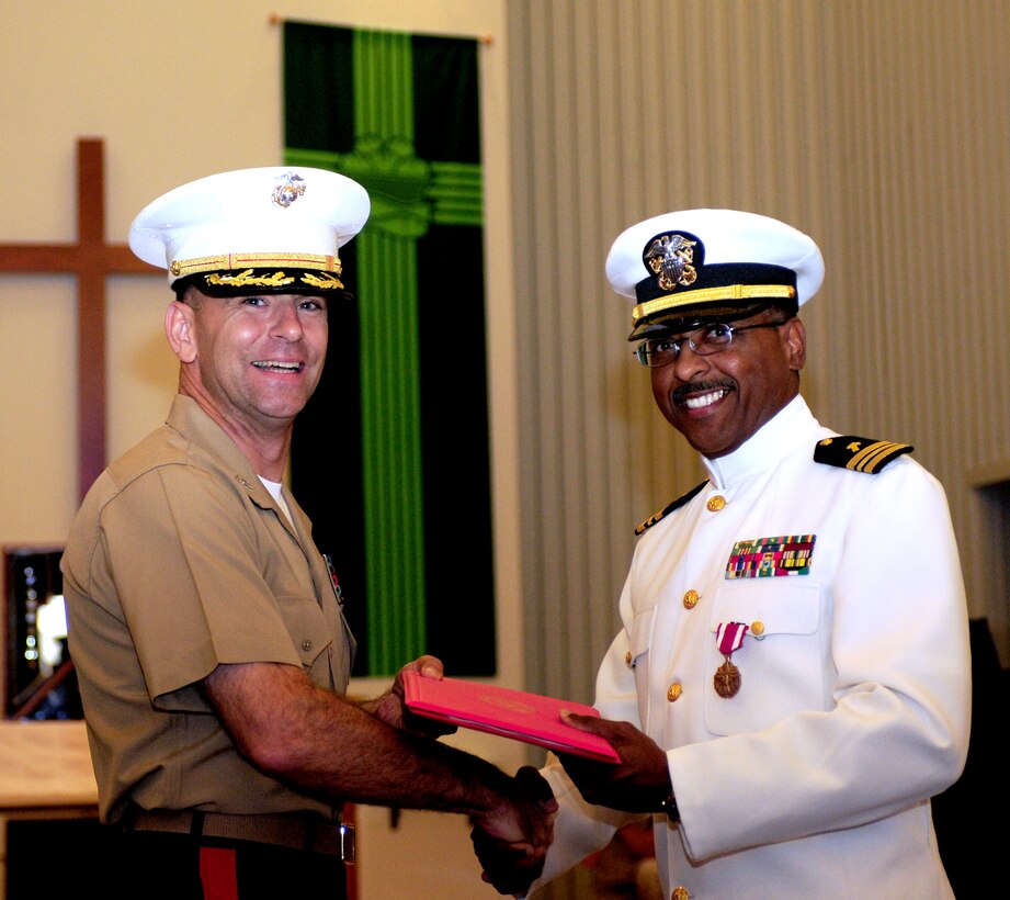 Col. Anton Nerad, left, Marine Aircraft Group 13 commanding officer, hands Lt. Cmdr. Carl H. Farmer the award warrant for Farmer's Meritorious Service Medal during the chaplain's retirement ceremony at Marine Corps Air Station in Yuma, Ariz., Sept. 28, 2010.