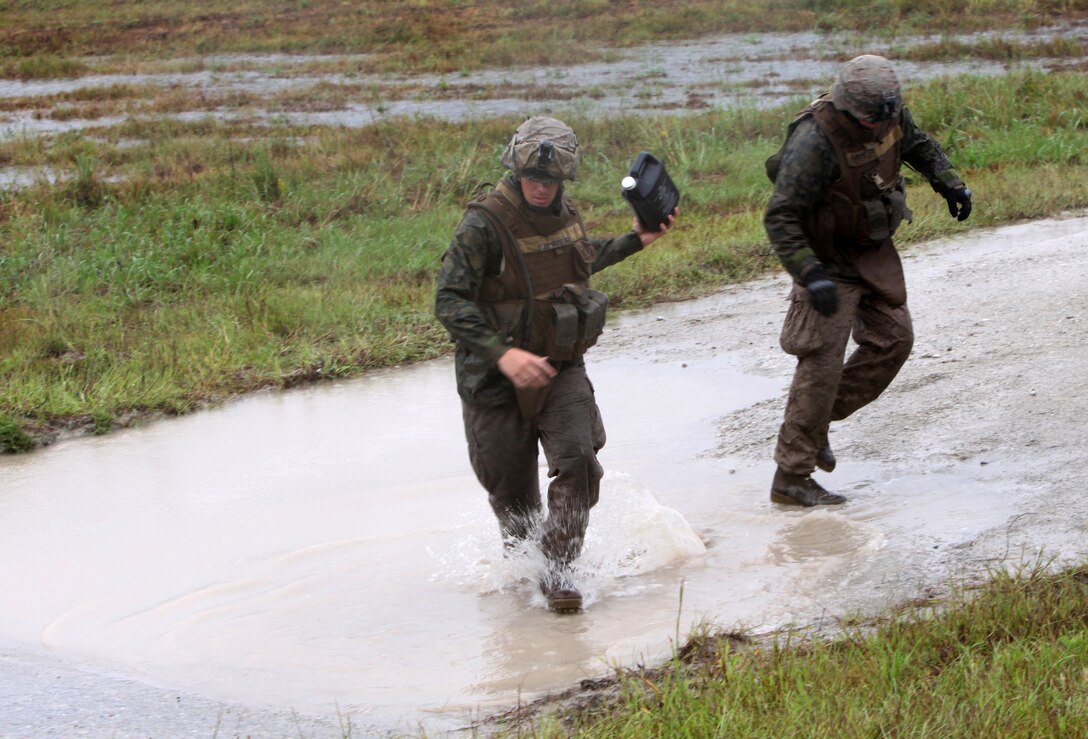 MARINE CORPS BASE CAMP LEJEUNE, N.C. - Lance Corporal Robert A. Bouchard, left, a Dothan, Ala., native, receives a jug of CLP, a Marine Corps acronym for Cleaner, Lubricant and Preservative, used for cleaning weapons, from Lance Cpl. Levi S. Davis, a Fort Worth, Texas, native, both machine gun squad leaders with 2nd Battalion, 2nd Marine Regiment, during a live fire exercise aboard Camp Lejeune, N.C., Sept. 29, 2010. Companies Echo, Fox and Golf, spent several rainy days reiterating and advancing machine gun skills by shooting the M-240B medium machine gun, the M-2 heavy machine gun and the MK-19 40mm automatic grenade launcher.  (Official Marine Corps by Cpl. Justin M. Martinez)