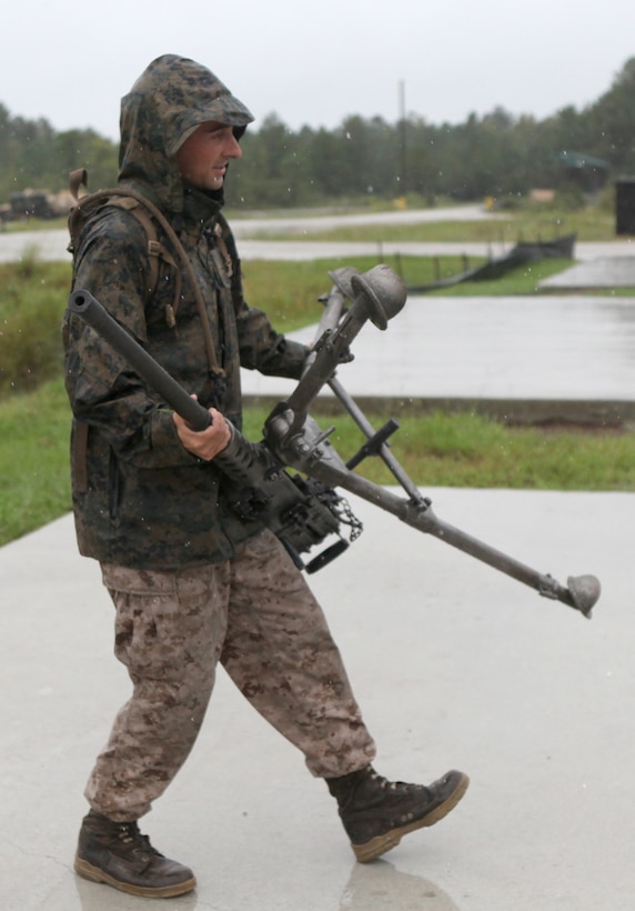 MARINE CORPS BASE CAMP LEJEUNE, N.C. - Lance Corporal Jason R. Little, a machine gunner with 2nd Battalion, 2nd Marine Regiment and Baltimore native, carries a .50-caliber Browning machine gun out of the rain at the conclusion of a live fire exercise conducted aboard Camp Lejeune, N.C., Sept. 29, 2010. Companies Echo, Fox and Golf, spent several rainy days reiterating and advancing machine gun skills by shooting the M-240B medium machine gun, the M-2 heavy machine gun and the MK-19 40mm automatic grenade launcher. (Official Marine Corps by Cpl. Justin M. Martinez)