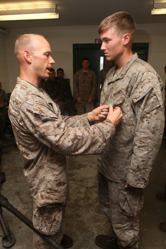 MARINE CORPS BASE CAMP LEJEUNE, N.C. - Second Battalion, 2nd Marine Regiment Commanding Officer Lt. Col. Gordon D. Miller, awards Lance Cpl. Calvin J. Carlson, a battalion machine gun section leader and Grant, Mich., native, the Navy & Marine Corps Achievement Medal after conducting a live firing range aboard Camp Lejeune, N.C. Sept. 29, 2010. Carlson recently served in a staff noncommissioned officers billet where he led his fellow Marines with professionalism and military tact. The battalion's Marines spent ten rainy days reiterating and advancing machine gun skills by shooting the M-240B medium machine gun, the M-2 heavy machine gun and the MK-19 40mm automatic grenade launcher. (Official Marine Corps by Cpl. Justin M. Martinez)