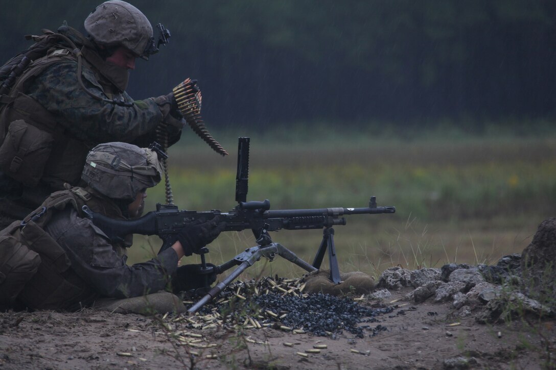 MARINE CORPS BASE CAMP LEJEUNE, N.C. - An assistant machine gunner, kneeling, with Echo Company, 2nd Battalion, 2nd Marine Regiment, reloads an M-240B medium machine gun with 7.62 rounds during a training evolution aboard Camp Lejeune, N.C., Sept. 29, 2010. Companies Echo, Fox and Golf, conducted a ten day training exercise including a MK-19 40mm automatic grenade launcher training course. (Official Marine Corps photo by Lance Cpl John M. Raufmann)