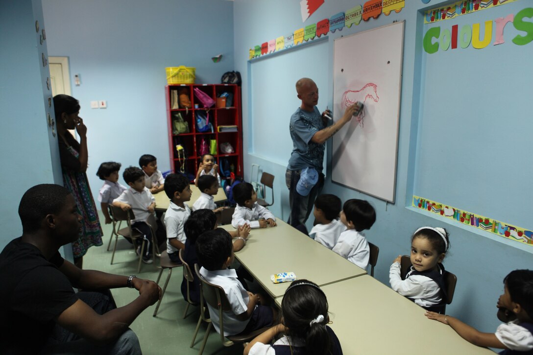 Sgt. Shane Worley, a military police officer assigned to Military Police Detachment, Headquarters Company, Combat Logistics Battalion 26, 26th Marine Expeditionary Unit (MEU) draws a draws a picture of a horse for children from the Regional Institute for Active Learning (RIA) Centre in Adliya, Bahrain, Sept. 29, 2010. The 26th MEU is embarked aboard ships of Kearsarge Amphibious Ready Group, supporting maritime security operations and theater security cooperation efforts in the U.S. 5th Fleet area of responsibility.