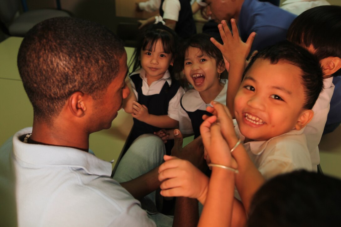 Seaman Weillson Millan, assigned aboard USS Ponce (LPD 15) plays with children from the Regional Institute for Active Learning (RIA) Centre in Adliya, Bahrain, Sept. 29, 2010. Ponce is deployed as part of Kearsarge Amphibious Ready Group, supporting maritime security operations and theater security cooperation efforts in the U.S. 5th Fleet area of responsibility.