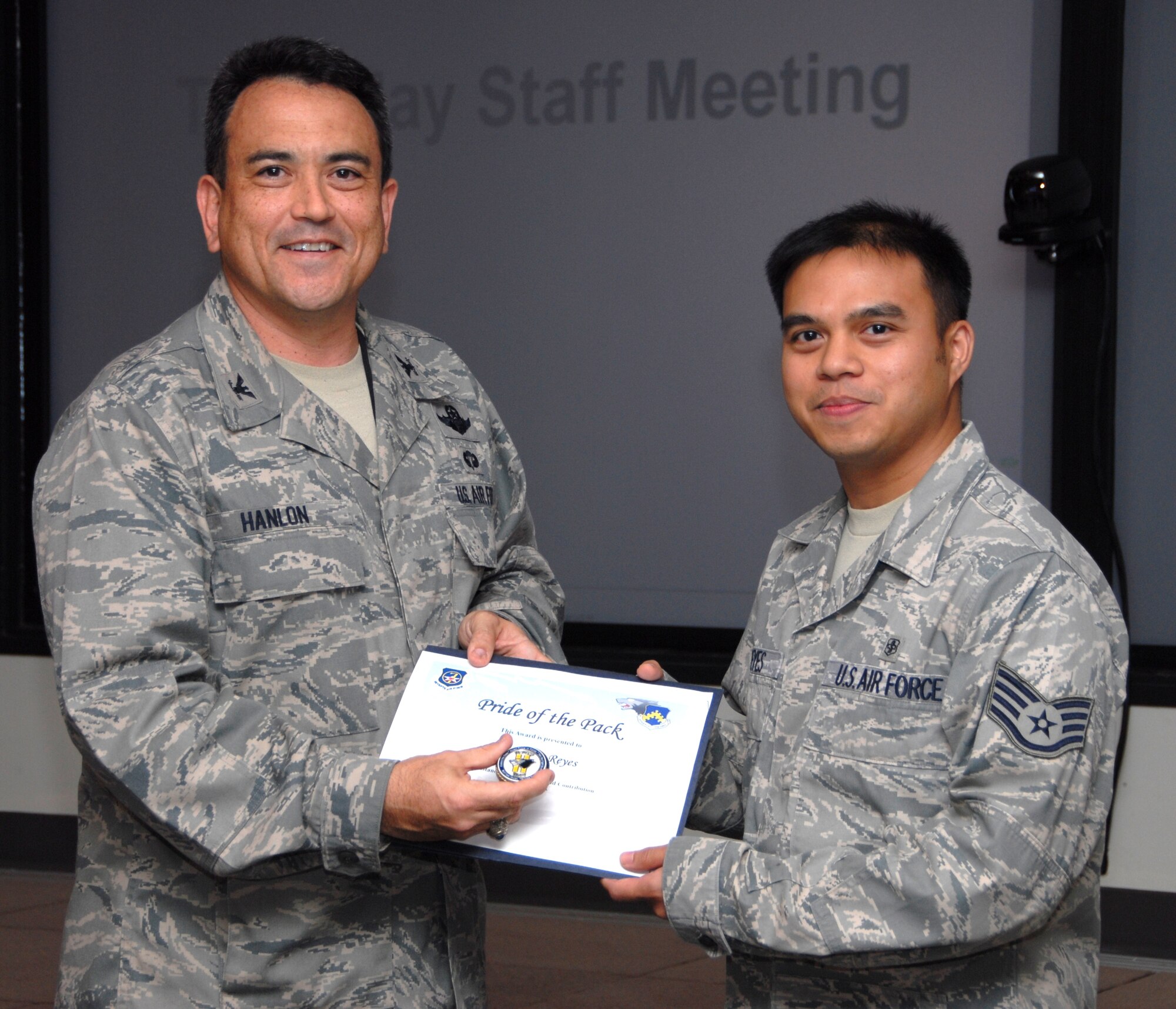 KUNSAN AIR BASE, Republic of Korea -- Col. Hugh Hanlon, 8th Fighter Wing vice commander, presents Staff Sgt. John Reyes, 8th Medical Operations Squadron, with a Pride of the Pack award Sept. 23. (U.S. Air Force photo/Staff Sgt. Amanda Savannah)