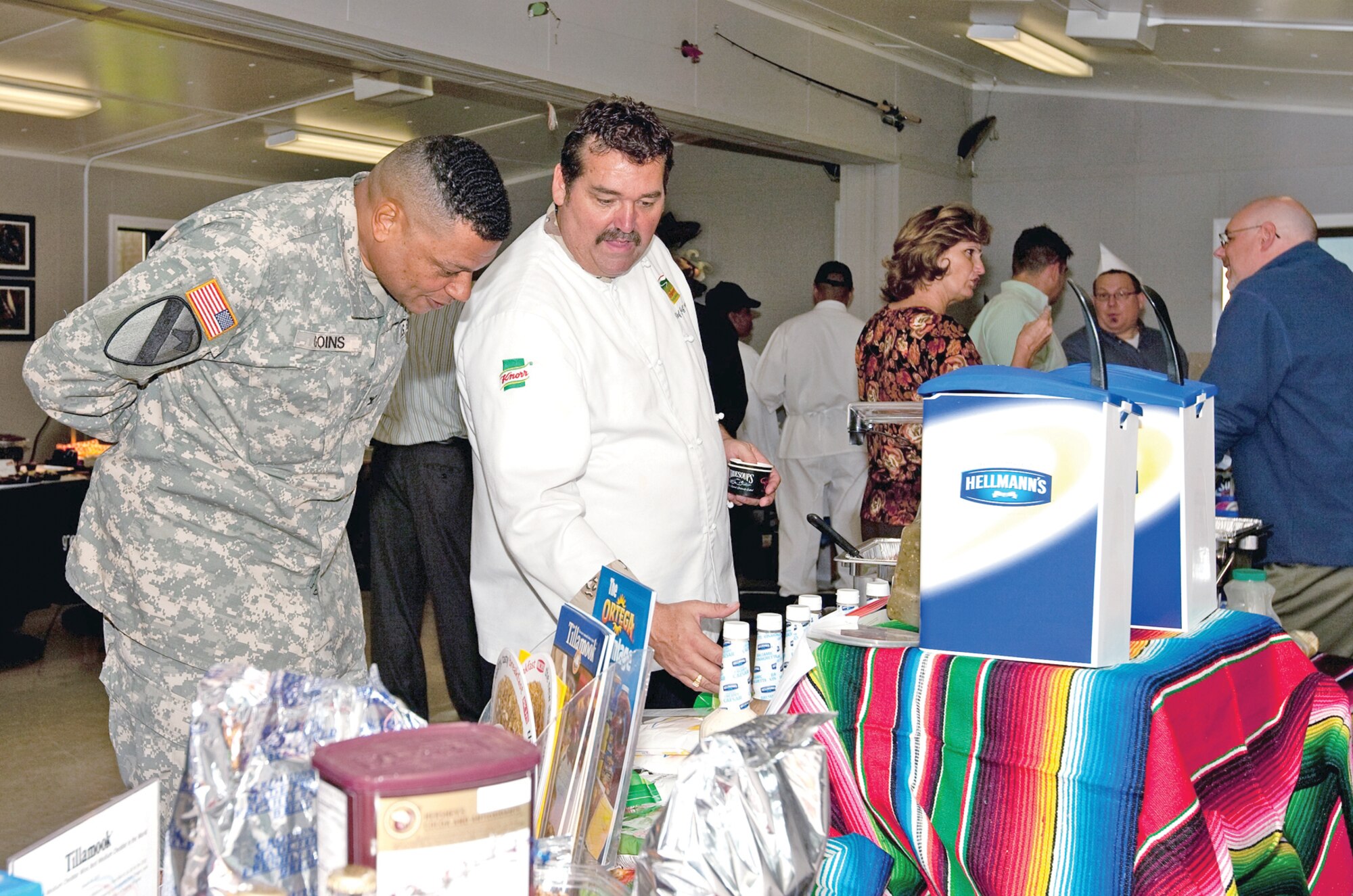 Army Col. Morris Goins, 4th Brigade Combat Team (Airborne), 25th Infantry Division commander, looks on as Chef Jeff Bennett, manufacturing representative for Unilever Foodsolutions, explains the variety of products on display during the Wilderness Inn Food Show. (U.S. Army photo by Mr. Percy Jones/JBER PAO)